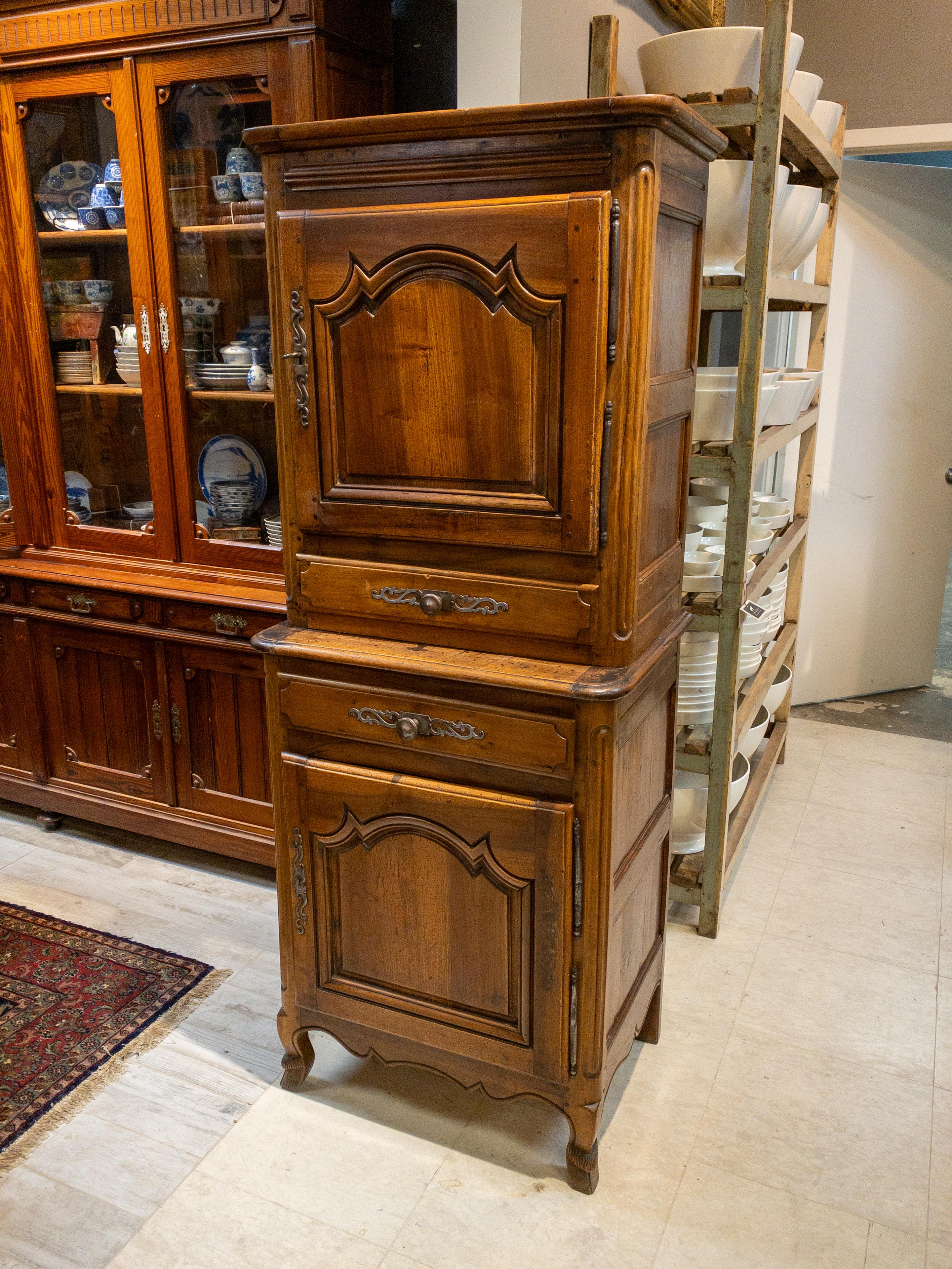 Crafted in the opulent style of 18th Century France, this exquisite Fruitwood Cabinet is a triumph of artistry and functionality. The upper compartment boasts a lockable door adorned with detailed carvings, secured by an ornate key. Inside, a