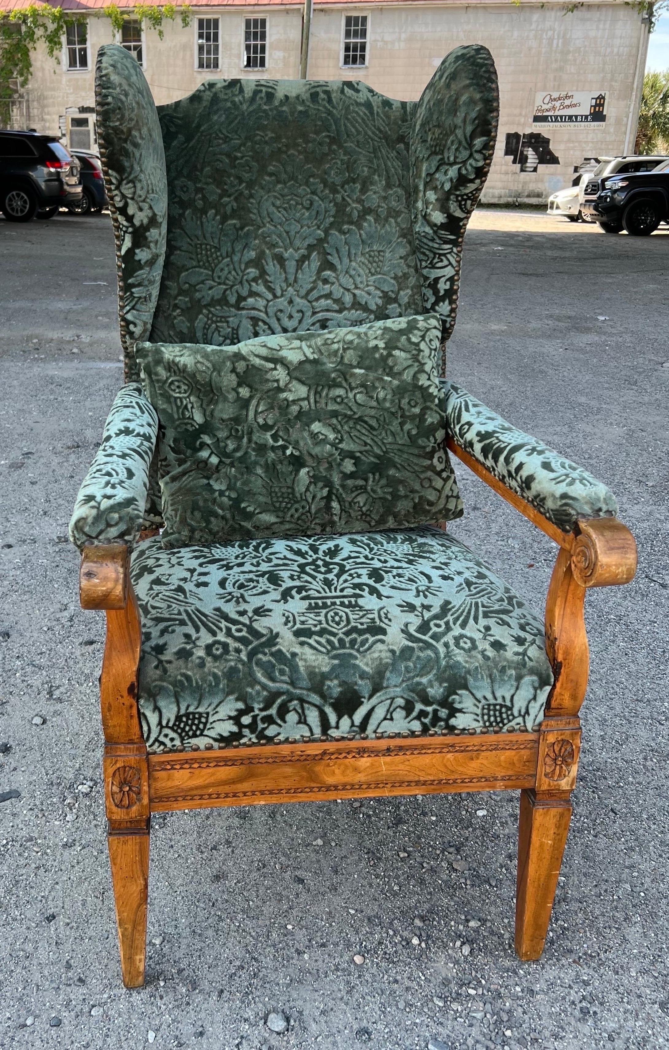 18th Century French Fruitwood Fauteuil À Oreills in Fortuny Fabric with pillow. Rich honey colored fruitwood with scrolled arms and carved patera on knees paired with elegant Fortuny fabric and matching pillow.