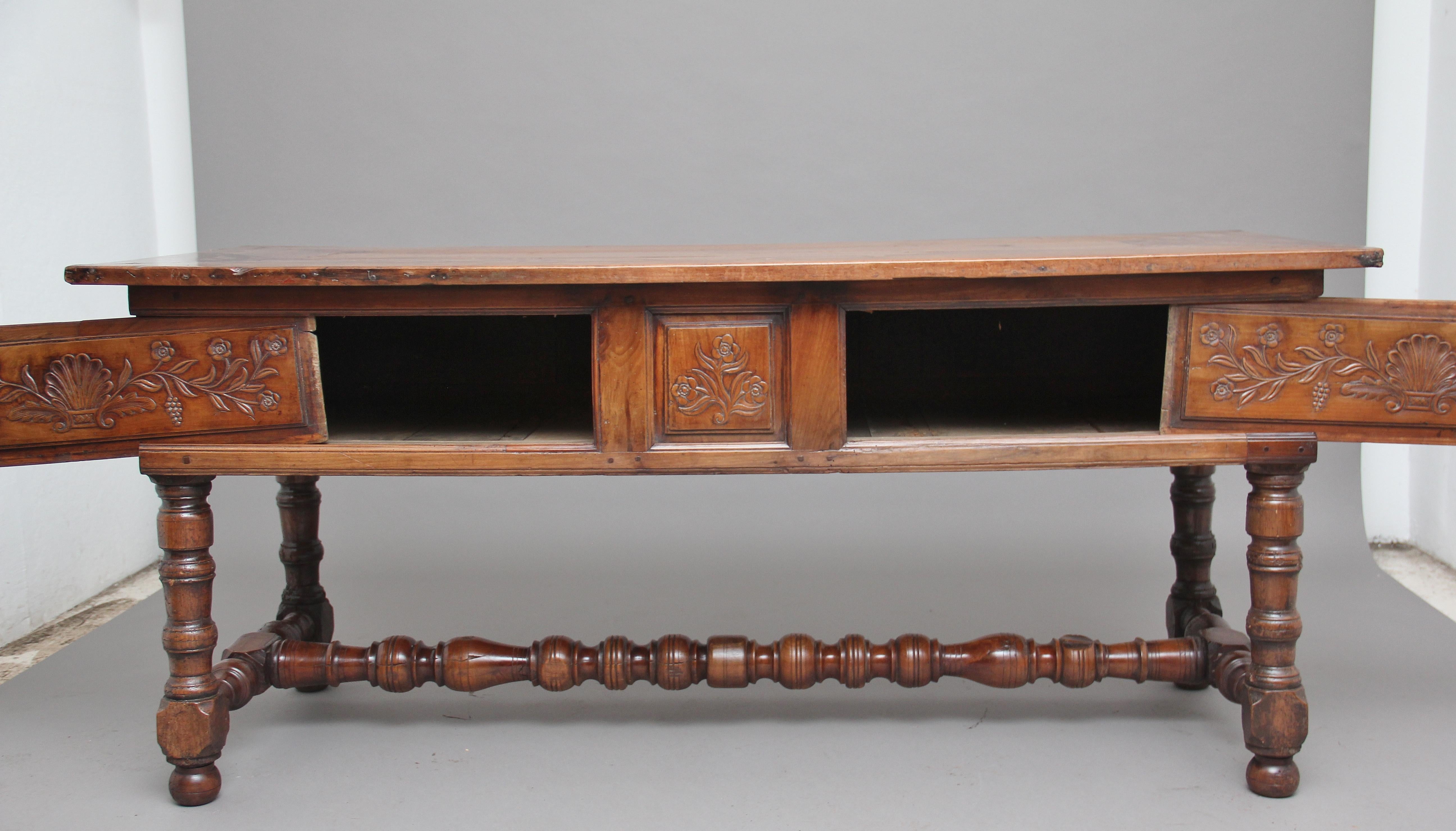 18th century French fruitwood serving / side table, having a nice figured top bursting with character, with two slide carved panels below opening to reveal cupboard space, the panels having carved floral and shell decoration, with a fixed central