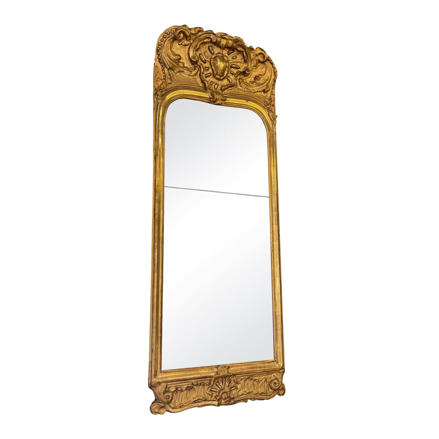 A gold antique French Rocaille décor gilded wood mirror with facet, in good condition. The mirrored glass is original. The mirror represents the Rococo time period. Minor fading, due to age. Wear consistent with age and use. Circa 1760, France.
    