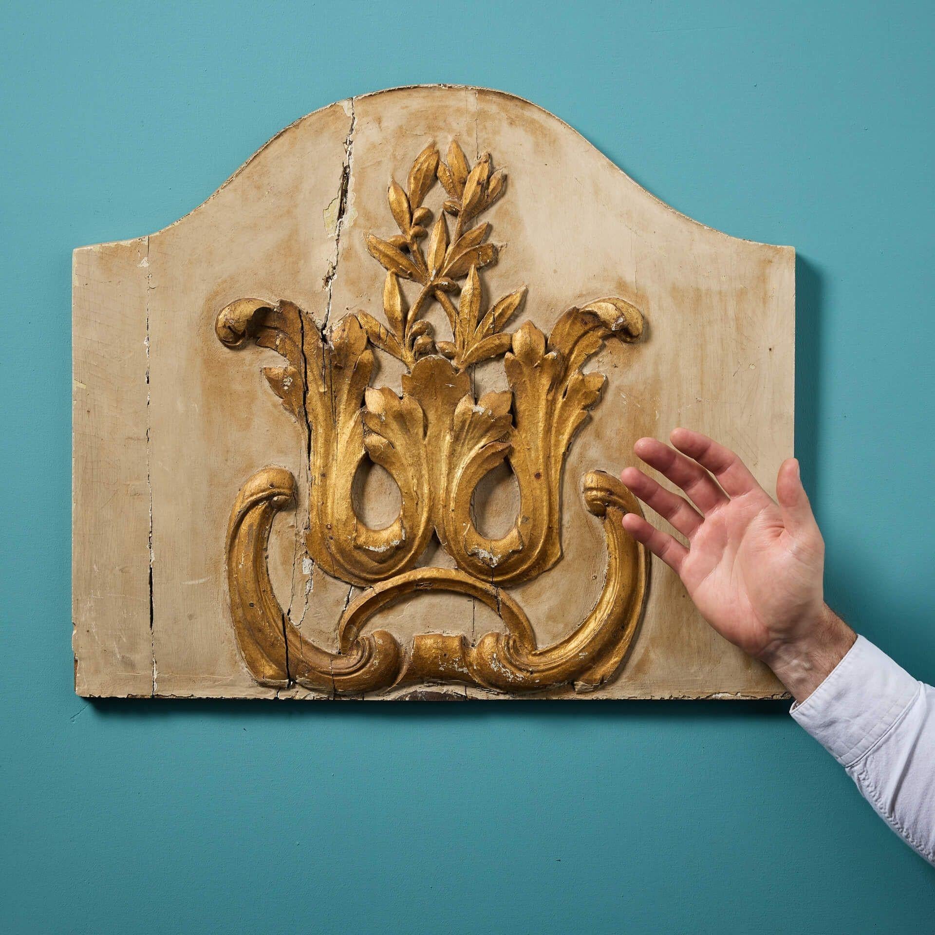 Placa mural dorada francesa del siglo XVIII, datada hacia 1750. Este panel de forma ornamental formaría parte originalmente de un interior panelado y se ha adaptado como adorno colgado de la pared.

El follaje tallado a mano tiene un impresionante
