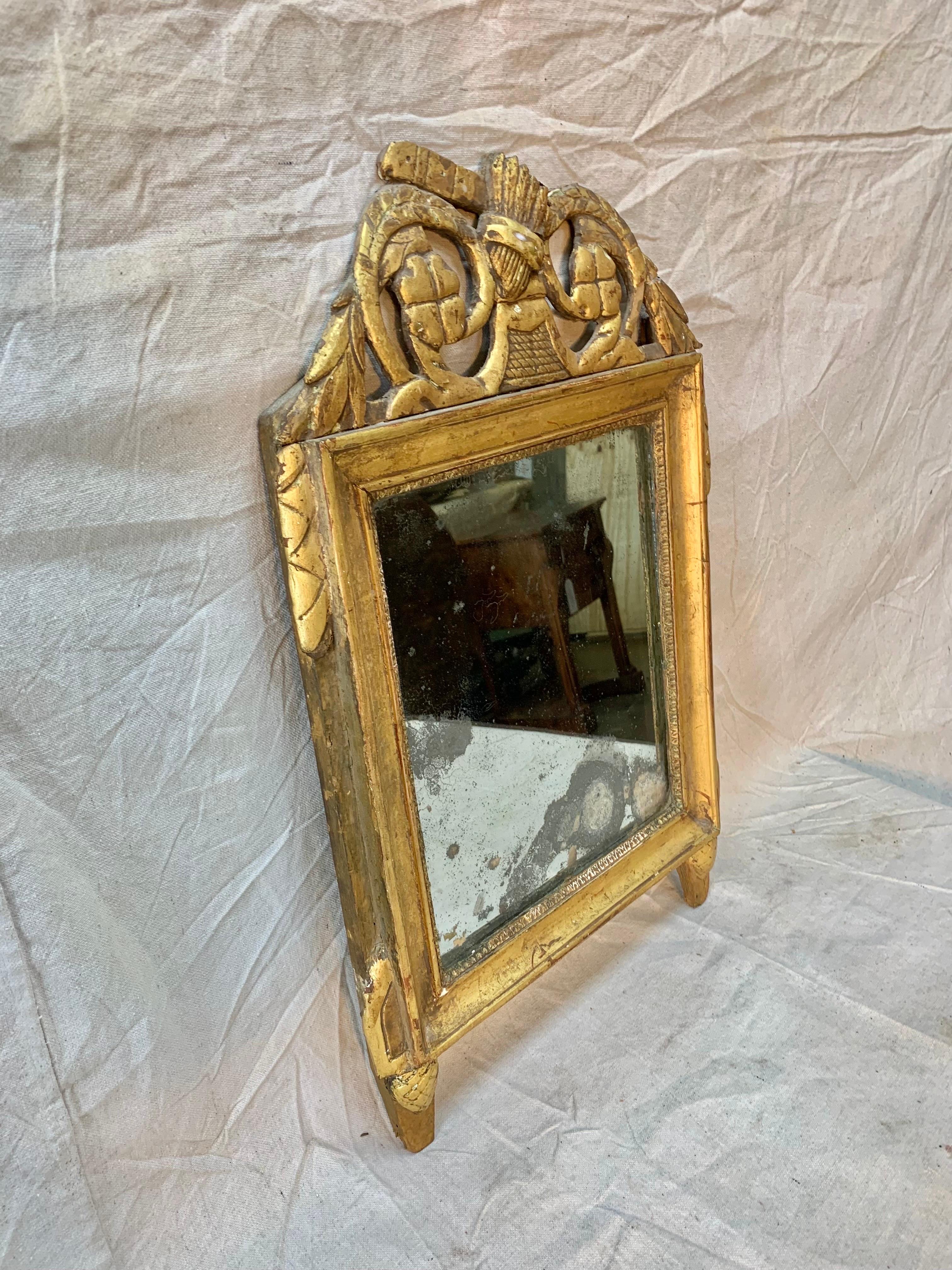 Presented as found, this beautiful Mid 18th Century Carved and Gilded French Wall Mirror features decorative details of foliage. The mirrored glass has some spotting and crazing which adds to the patina of the piece. Newly wired and ready to