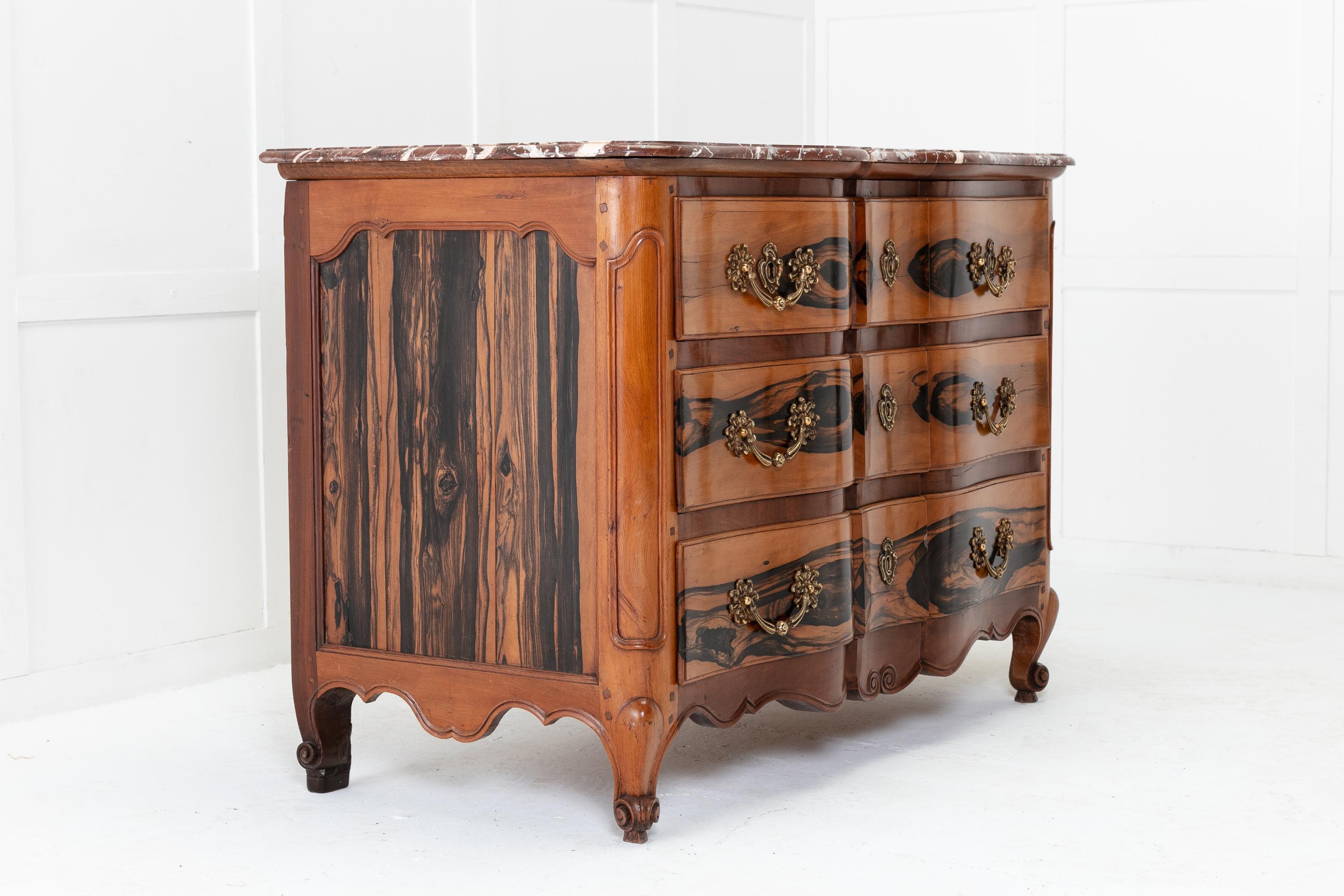 A stunning 18th century French guaiac wood and walnut commode with shaped, marble top. Having a very nice shaped front and moulded panel sides, with excellent use of solid guaiac wood. Having moulded, canted corner panels to the front, with three