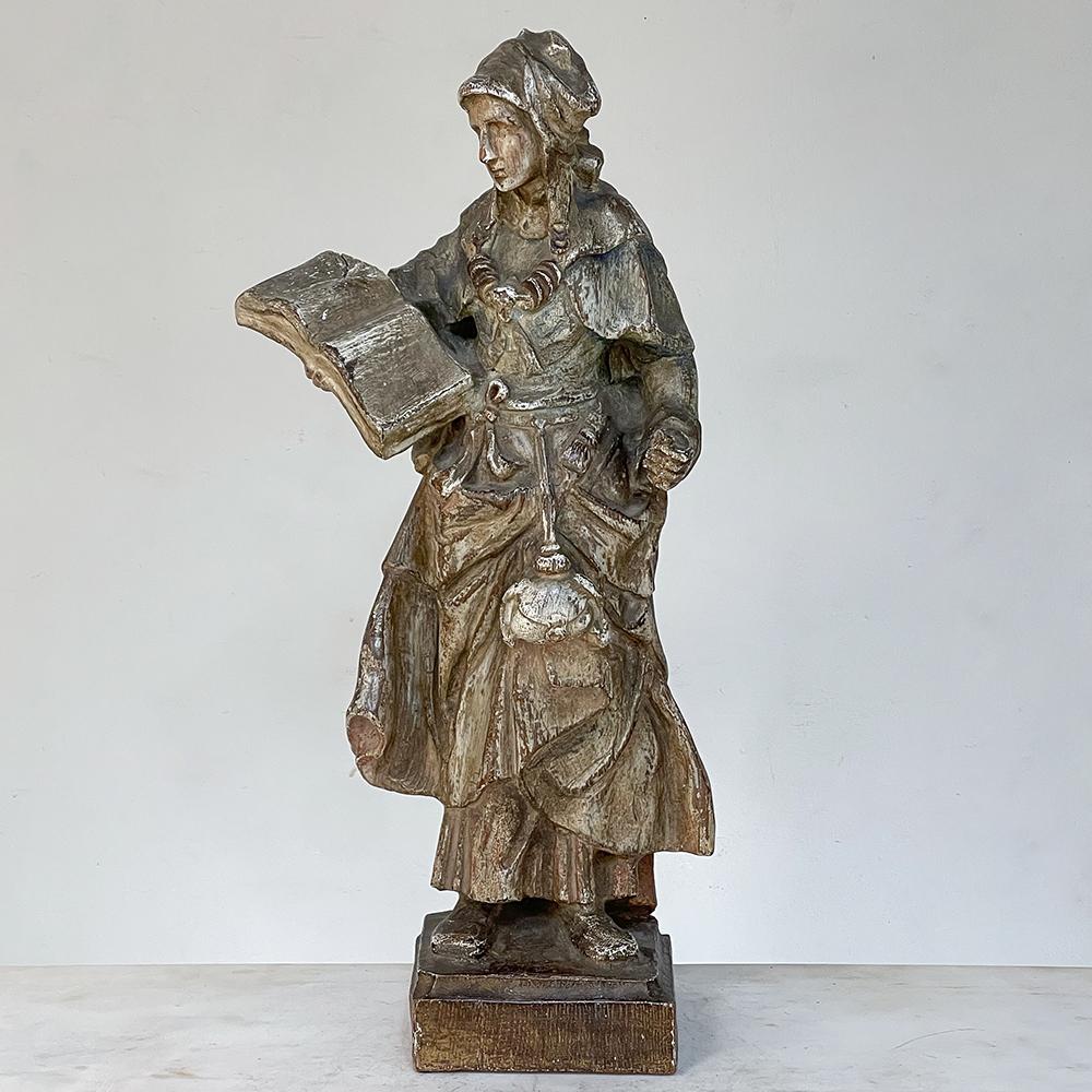 18th century French hand carved and painted wood statue still shows vestiges of its original painted finish. Depicting a nun reading a bible, the nun's garments are of particular interest to students of sculpture. The simple garments are augmented