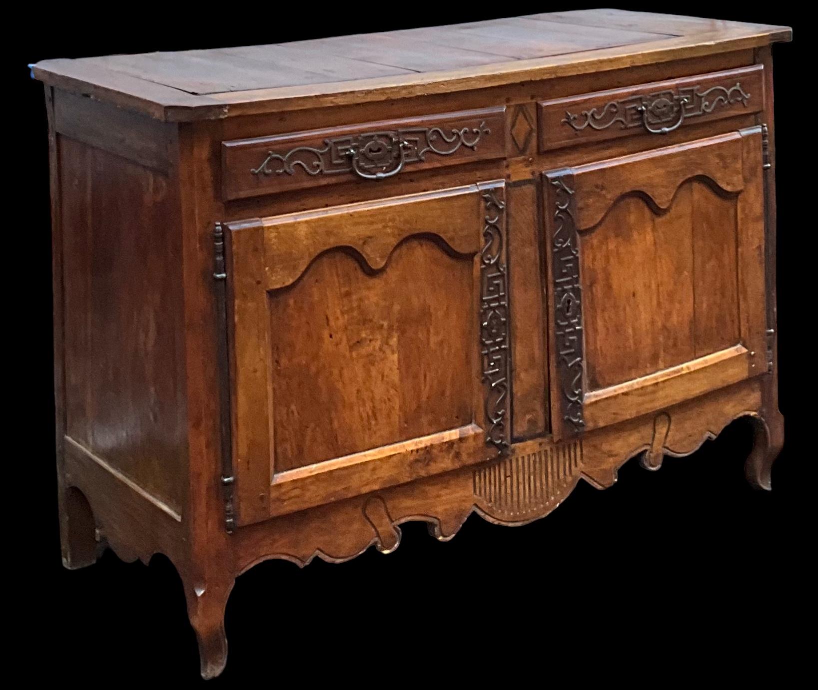 This is a hand hewn Louis XV carved fruitwood cabinet or sideboard. The iron hardware is wonderful. The piece opens to a single shelf. It is in very good antique condition. Just in time for the holidays. 