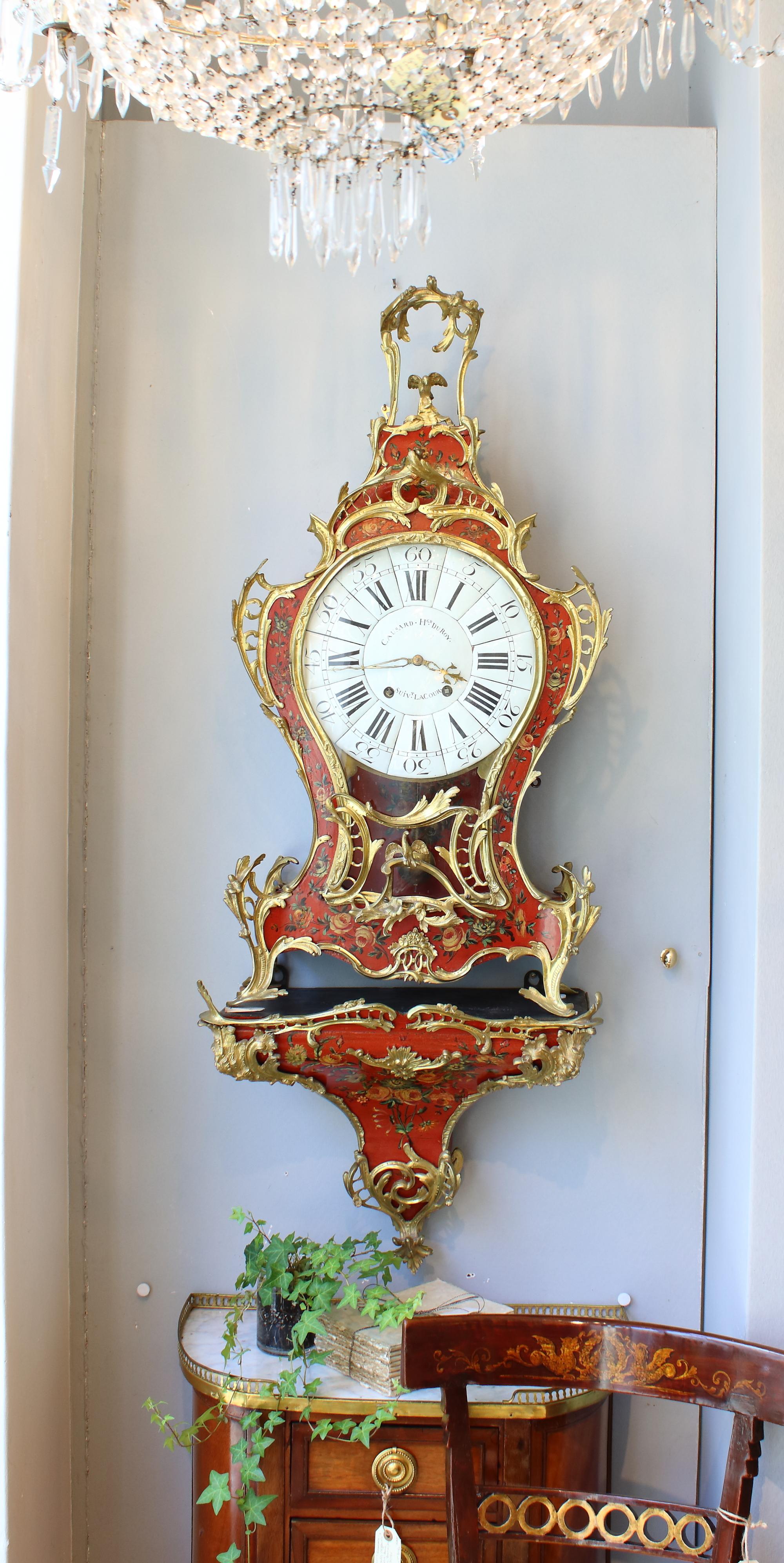 18th century French large Vernis Martin gilt bronze cartel clock and console

The impressive and large clock case decorated overall with very fine ‘Vernis Martin’ lacquer paint with floral sprays and garlands on a red background. The waisted case