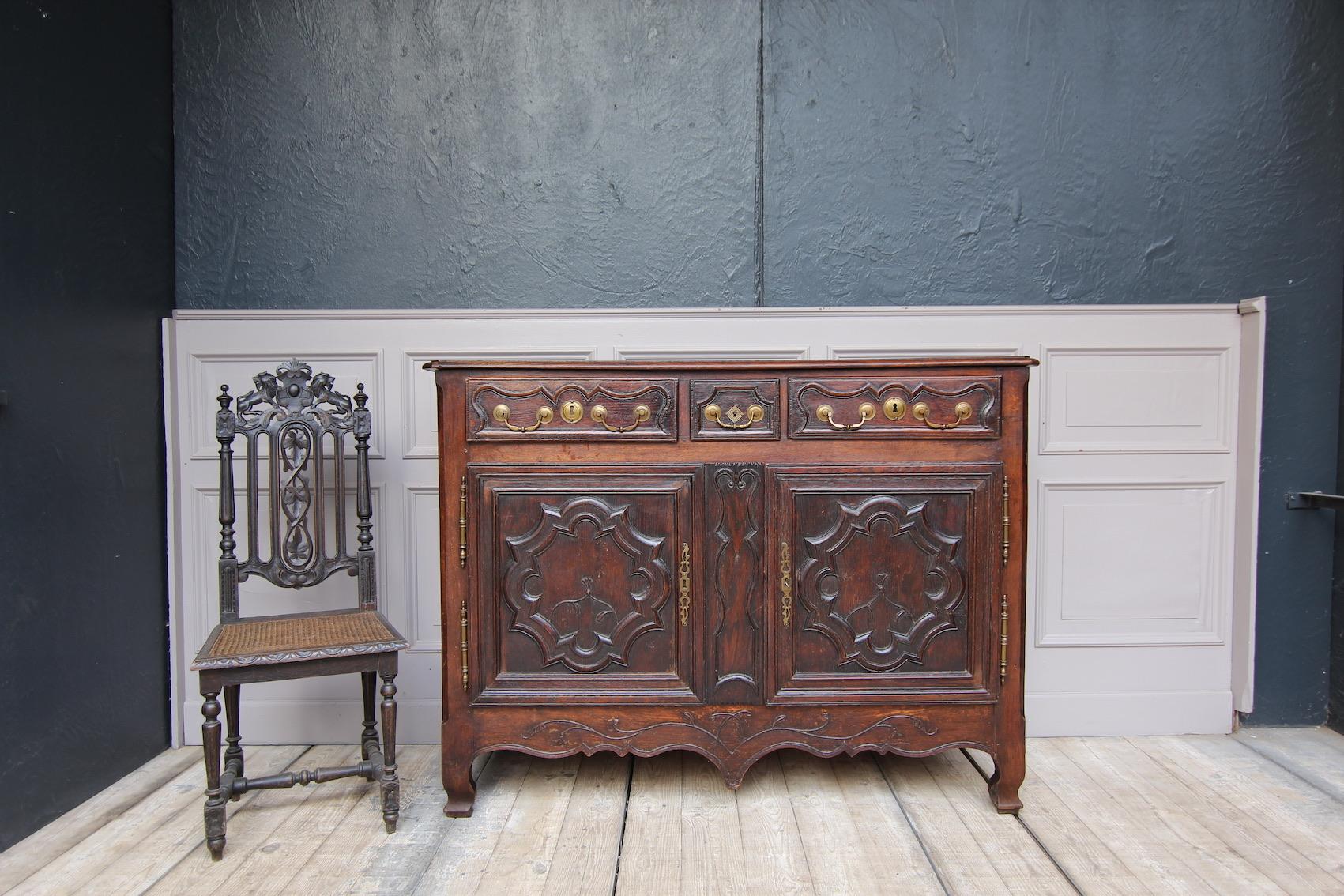 French sideboard made of oak. Lorraine, circa 1780.

Body with 2 doors on outside brass fittings and 3 drawers above with large brass handles.
Equipped with a shelf inside.

Dimensions: 
112 cm high / 44.09 inch high,
149 cm wide / 58.66 inch