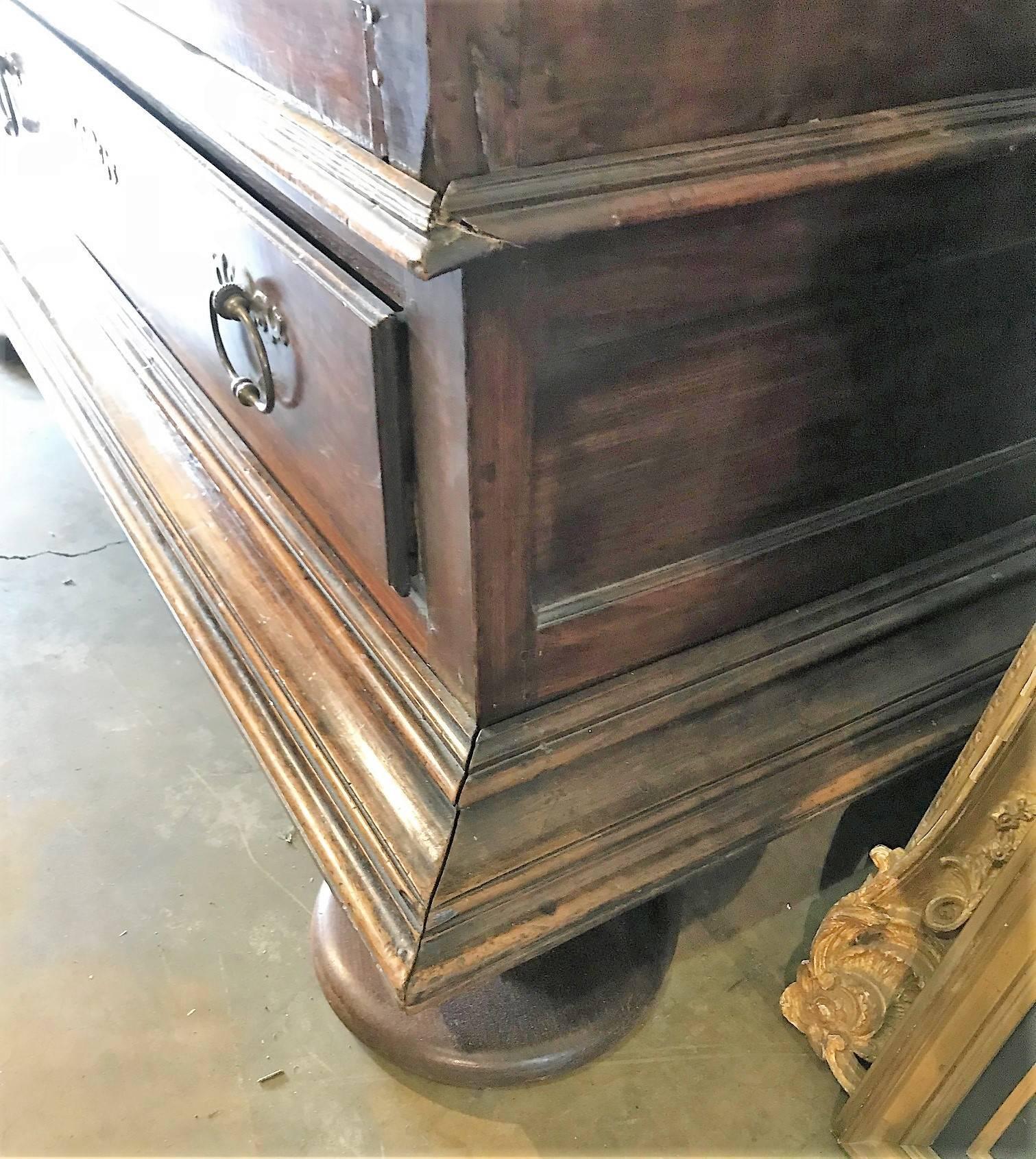 Exceptional and rare 18th century French Louis XIII château size armoire, crafted of rare Cuban mahogany. The large double doors with shaped inset panels atop a single long drawer. Retains the original hand wrought escutcheons and pulls and lock.