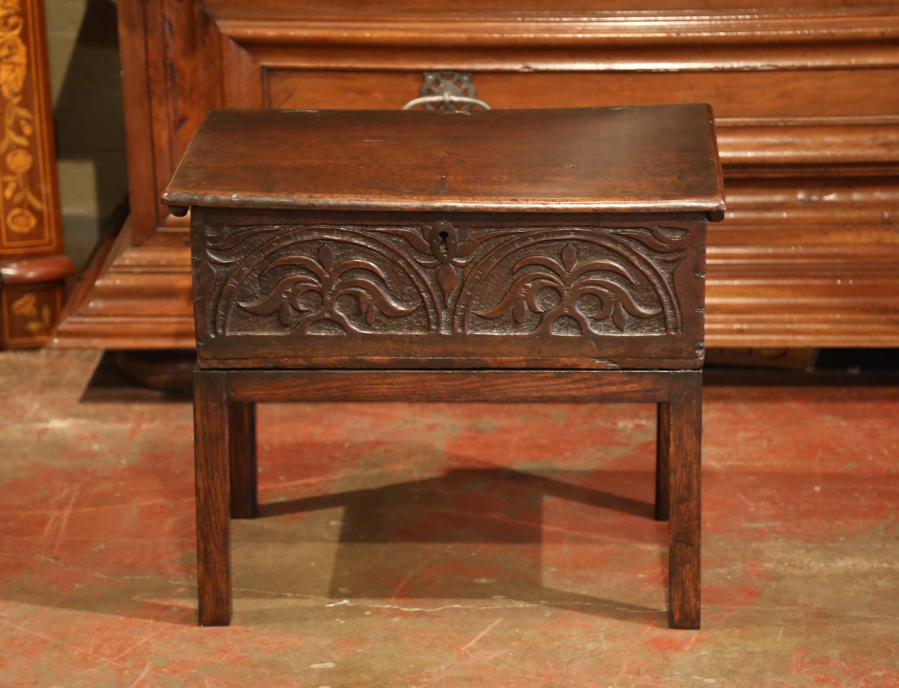 This antique box was carved in France, circa 1780. The trunk features deep carvings on the front with Fleurs-de-Lys on the facade, and opens from the top for inside storage. New legs have been adapted to the piece and turned it into a small end