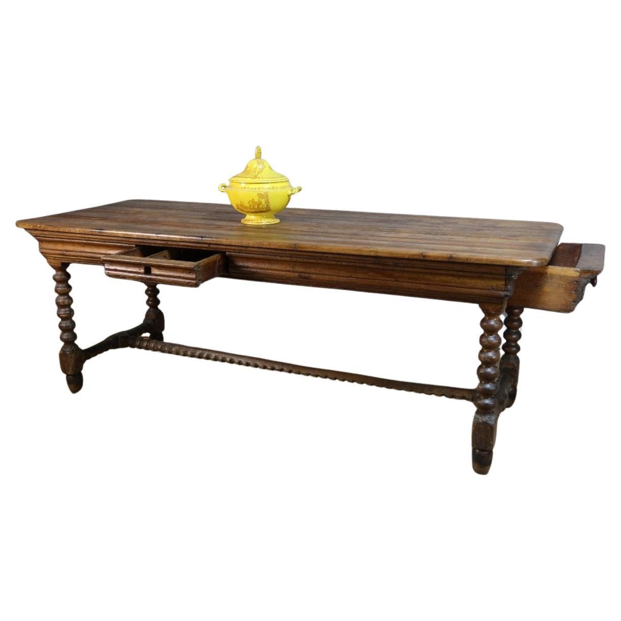Natural wood ogee sash table with two drawers. 
This table rests on four twisted legs joined by a 