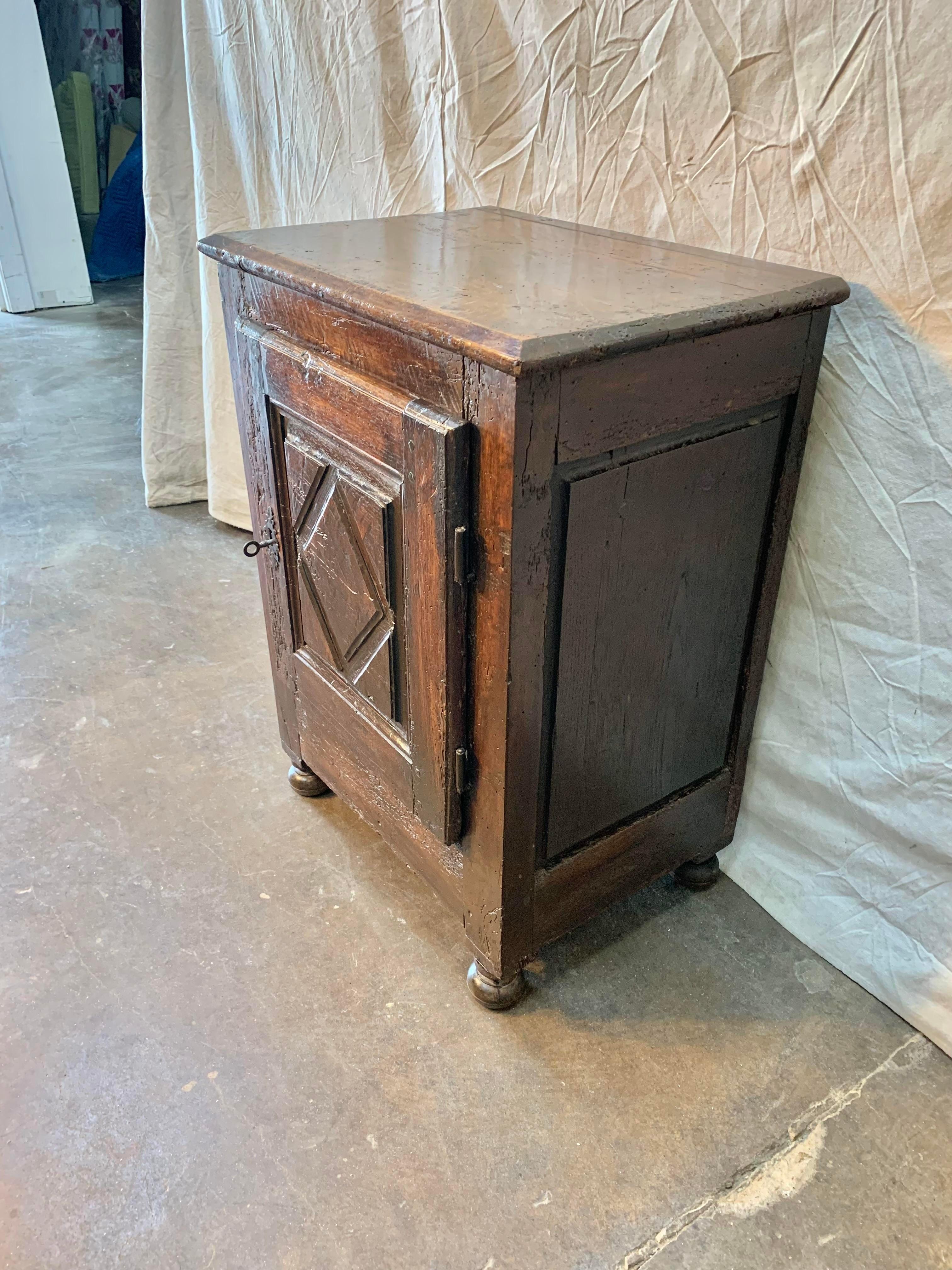 Found in the South of France, this 18th century French Louis XIII Style Cabinet De Confiture or jam cabinet was handcrafted of solid old growth oak. The piece features a beveled edge top resting over a single panel door carved in the typical Louis