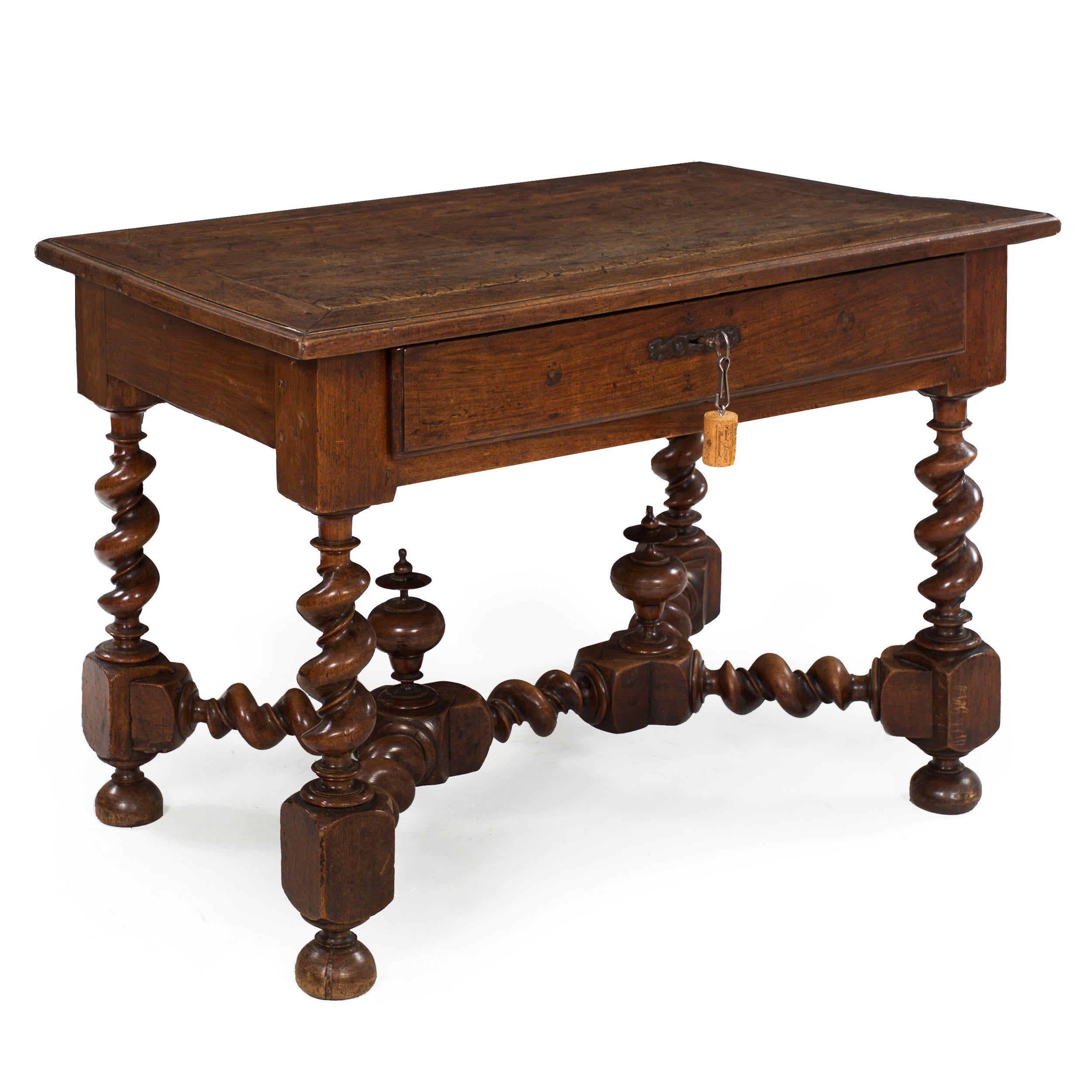 A rich and wonderful writing table from the first half of the 18th-century, this absolute strikepoint piece is entirely executed in solid walnut primary woods and retains wonderful wrought iron hardware. The top is designed with planks of walnut