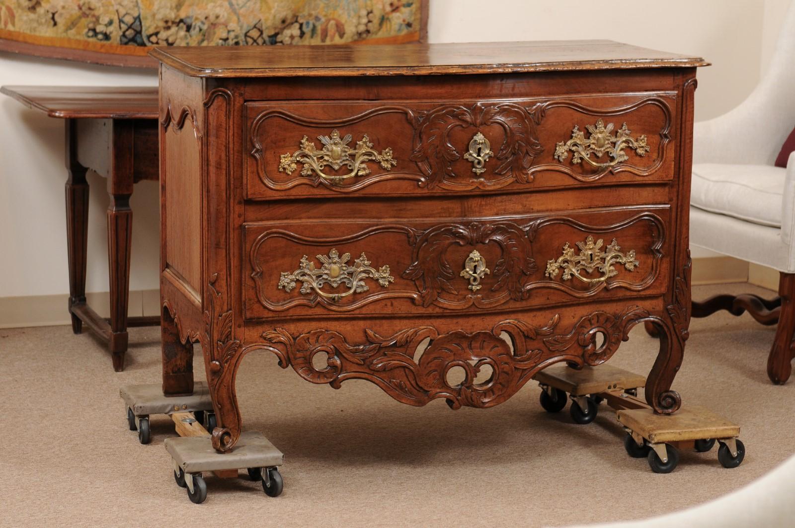 Louis XV period walnut commode with two (2) drawers, pierced carved apron, and cabriole legs, mid-18th century France.