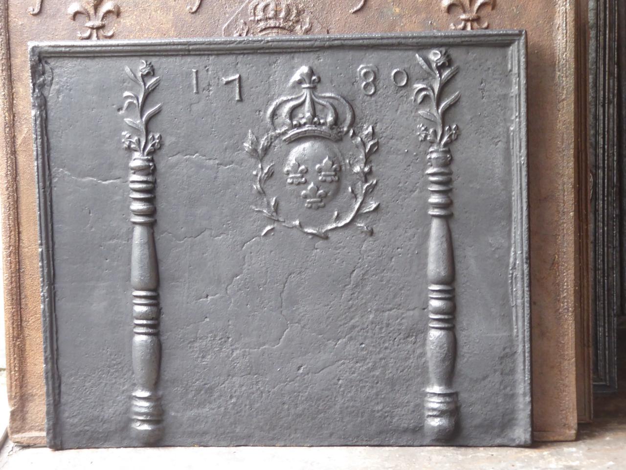 18th century French Louis XV fireback with two pillars of Hercules decorated with flower pots and the arms of France. The date of production, 1780, is also cast in the fireback. This is the coat of arms of the House of Bourbon, an originally French