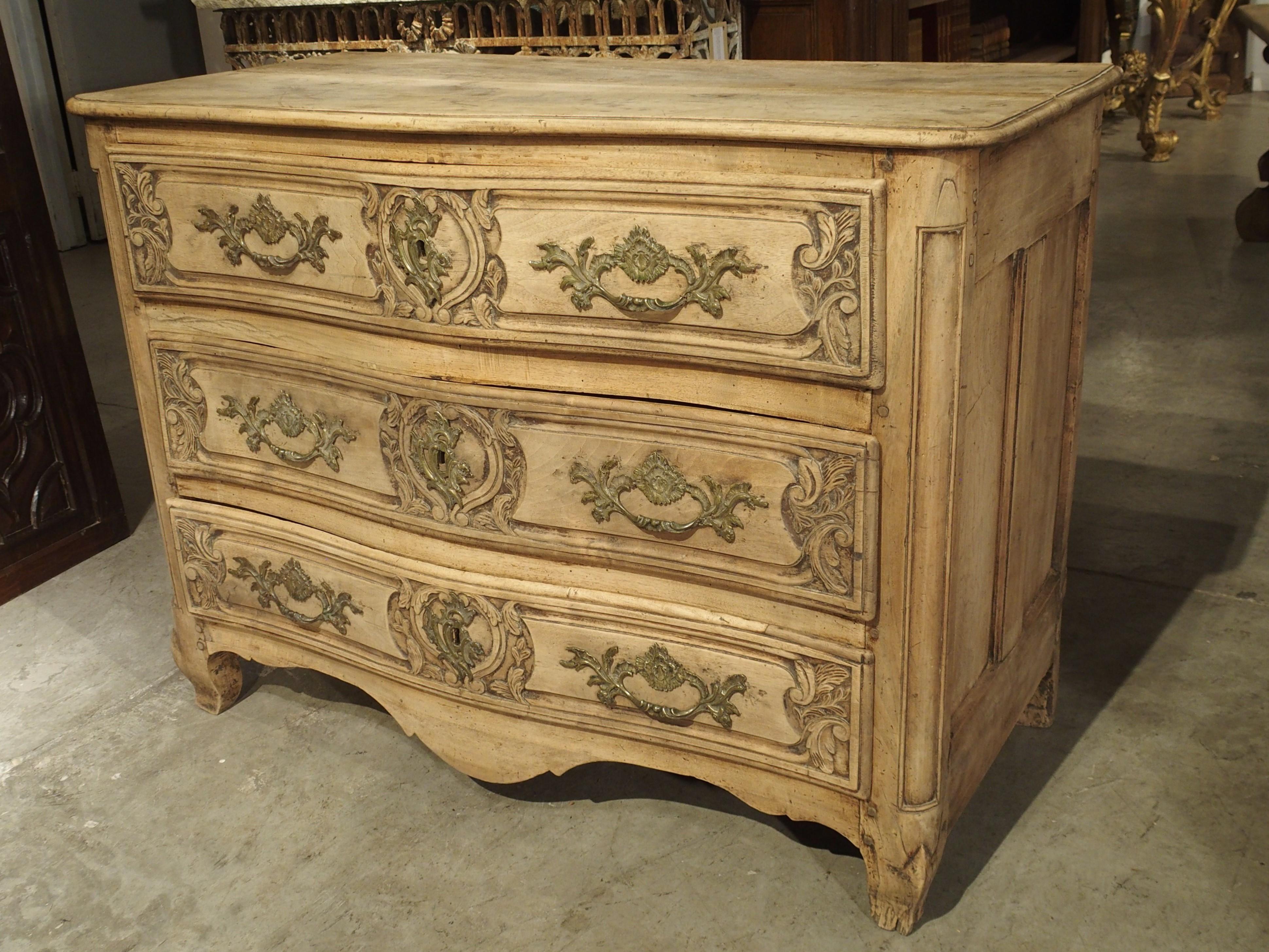 This is a wonderful example of a Lyonnaise Louis XV walnut wood commode constructed by a country cabinetmaker. The light color of the French walnut is a result of a bleaching process that removes the old stain and gives the piece a fresh and