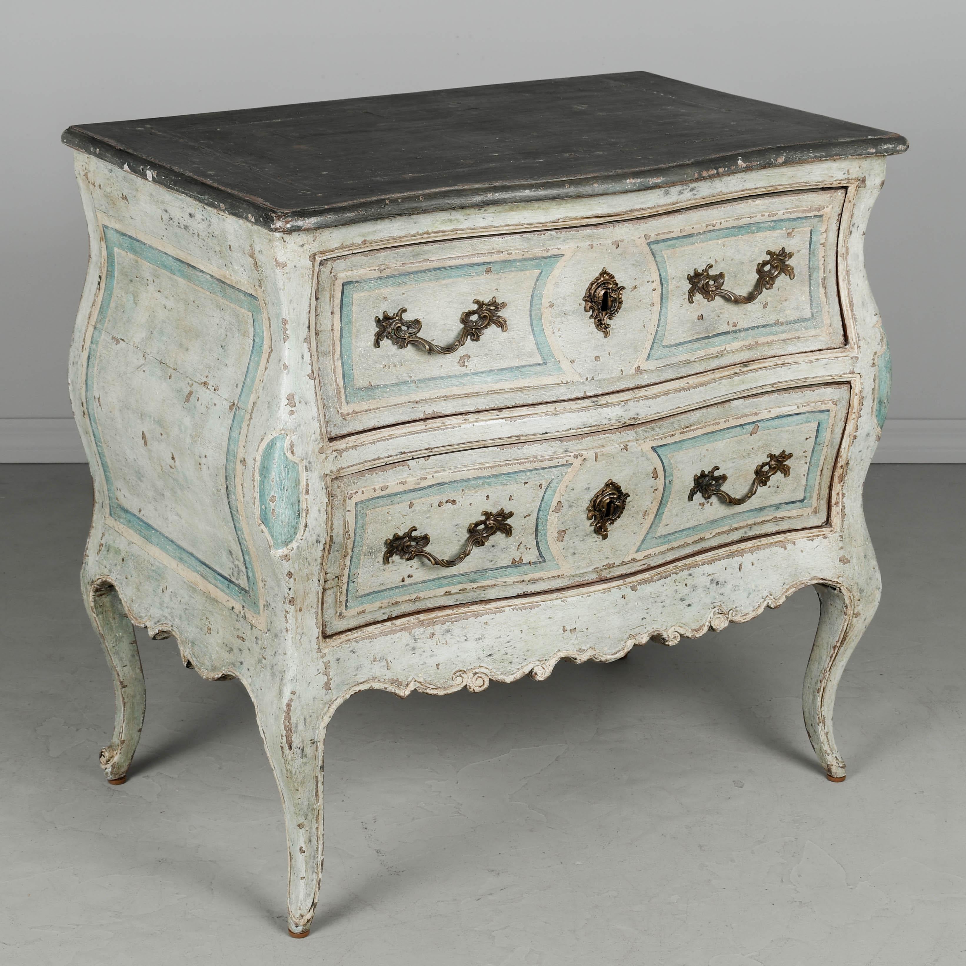 Commode Louis XV du XVIIIe siècle, originaire de la région de Bordeaux, en merisier massif avec une finition peinte en bleu. Forme bombée avec façade et côtés serpentins et détails sculptés subtils. Deux tiroirs à queue d'aronde avec poignées en