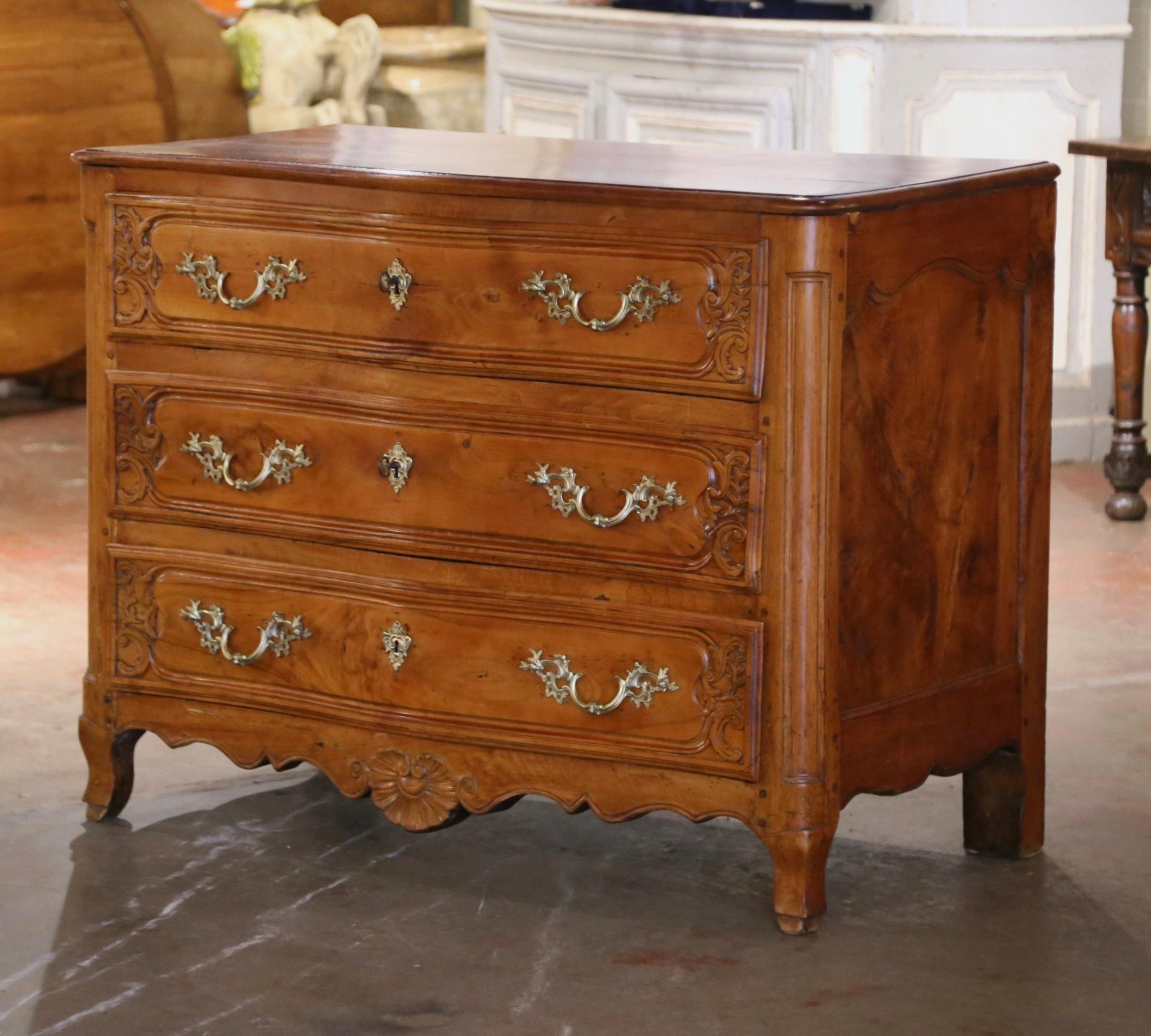 This elegant antique chest of drawers was crafted in Lyon, France, circa 1760. Built of elm and chestnut wood, the large fruitwood bombe 