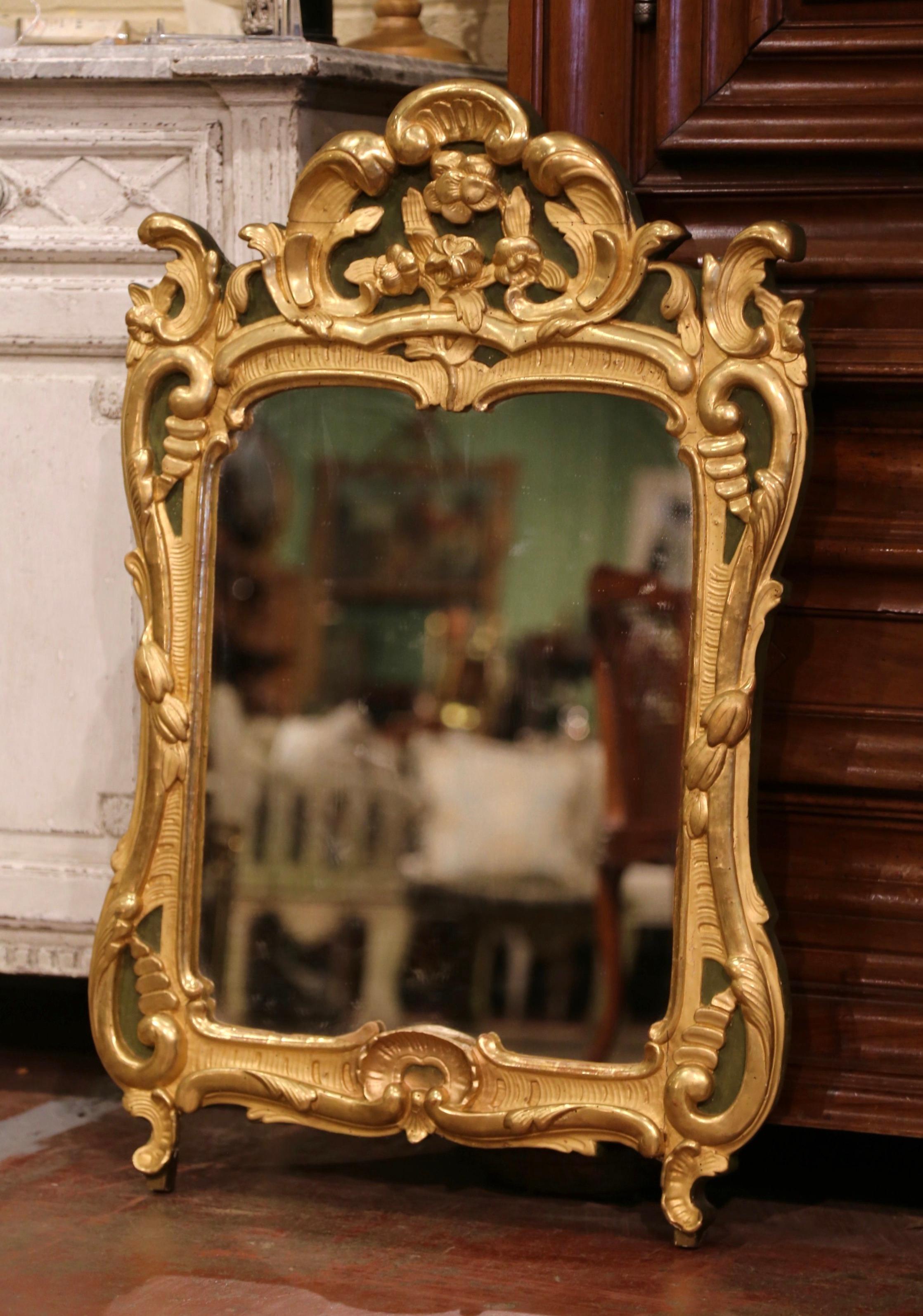 This elegant, antique gilt mirror would make a charming addition to an entryway or powder room. Crafted in Southern France, circa 1780, the rectangular Provincial mirror is heavily carved and exemplifies the design elements of the Rococo and Baroque