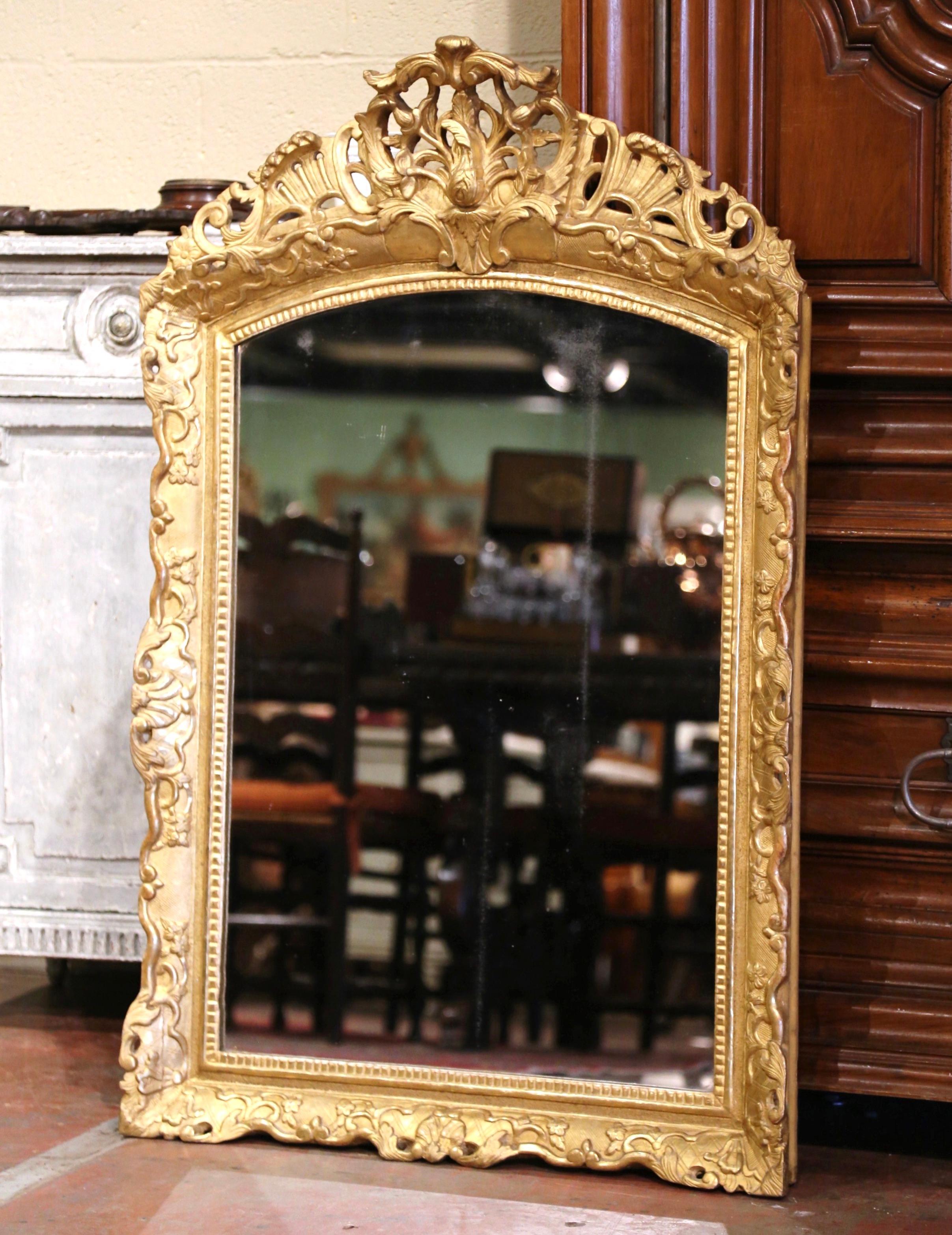 Dress a mantel with this elegant antique mirror. Crafted in Southern France, circa 1780, and arched at the top, the ornate frame features a pierced floral decor cartouche at the pediment with leaves and foliage motifs throughout. The Louis XV mirror