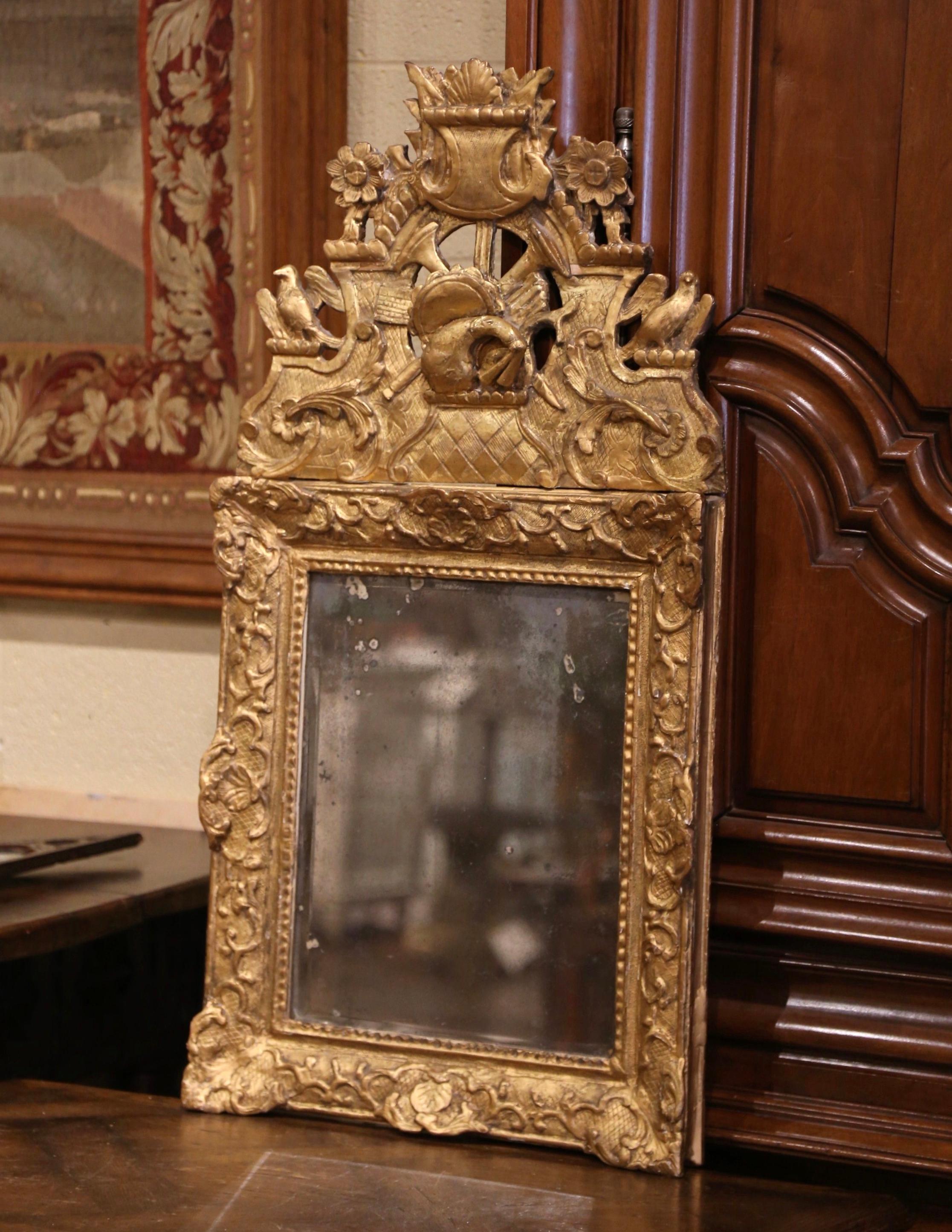 This elegant, antique mirror would make a charming addition to a hallway or powder room. Crafted in Southern France, circa 1780 and rectangular in shape, the gilt wood mirror is heavily carved and exemplifies the design elements of the Rococo and