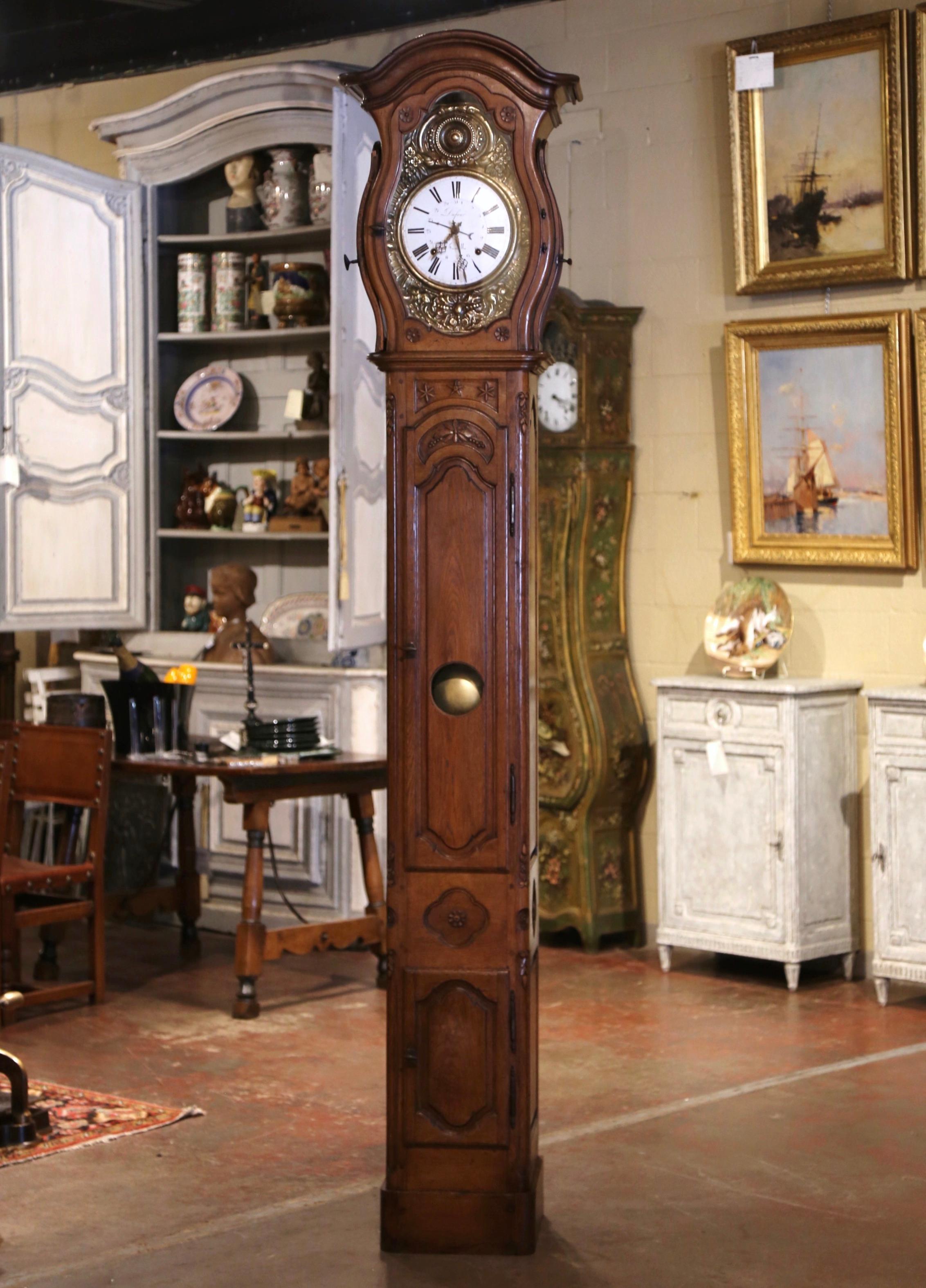This elegant, antique long case clock was crafted in Lyon, France, circa 1780. The tall grandfather clock stands on a thick bottom plinth; it features a curved bonnet top at the top with bowed sides dressed with glass doors in order to admire the