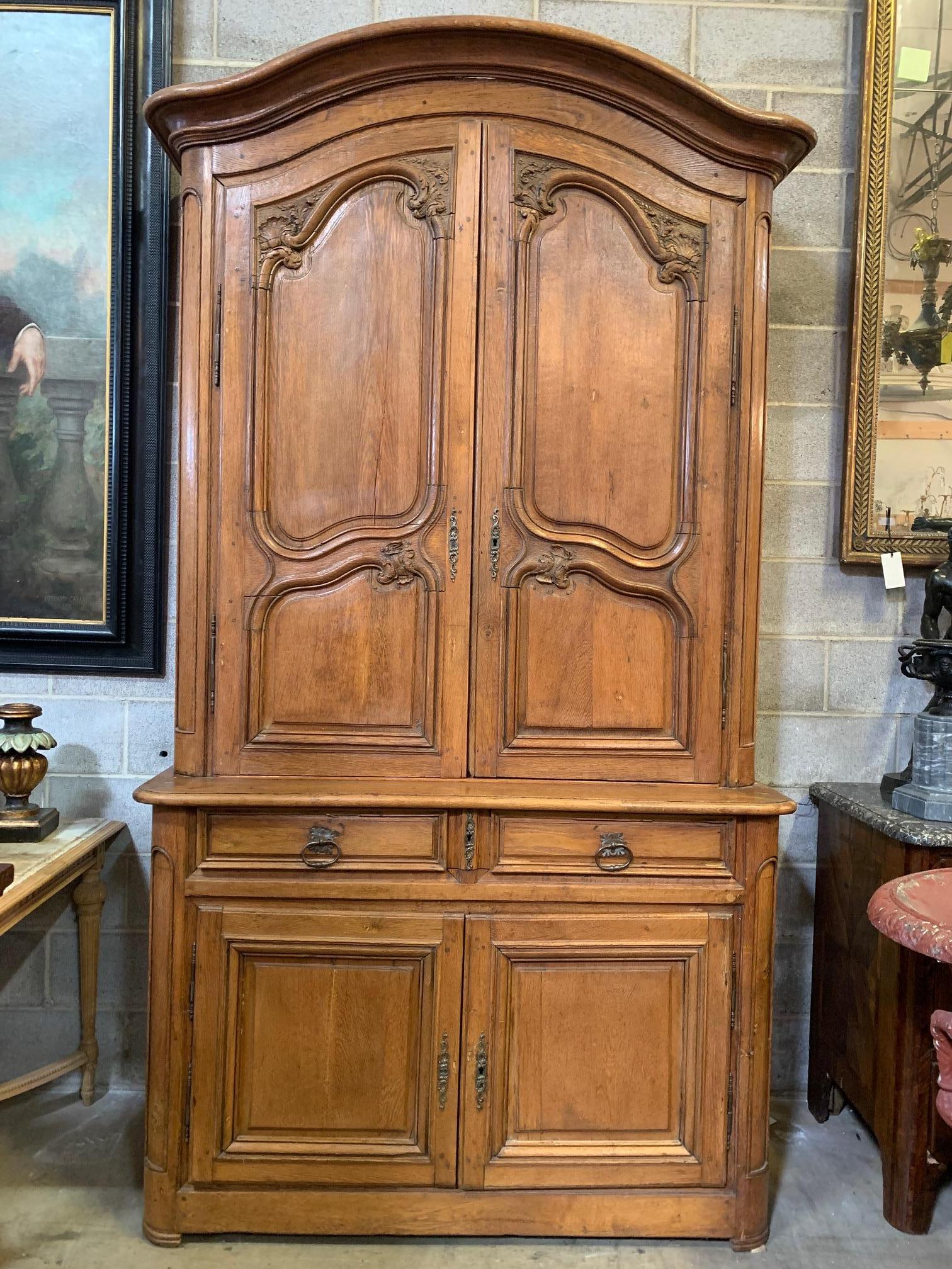 French Louis XV carved oak buffett a du corps from the 18th century. This two part cabinet is beautifully carved and has been lightened at an earlier time giving it a wonderful pale golden finish. The drawers have also been modified to create a