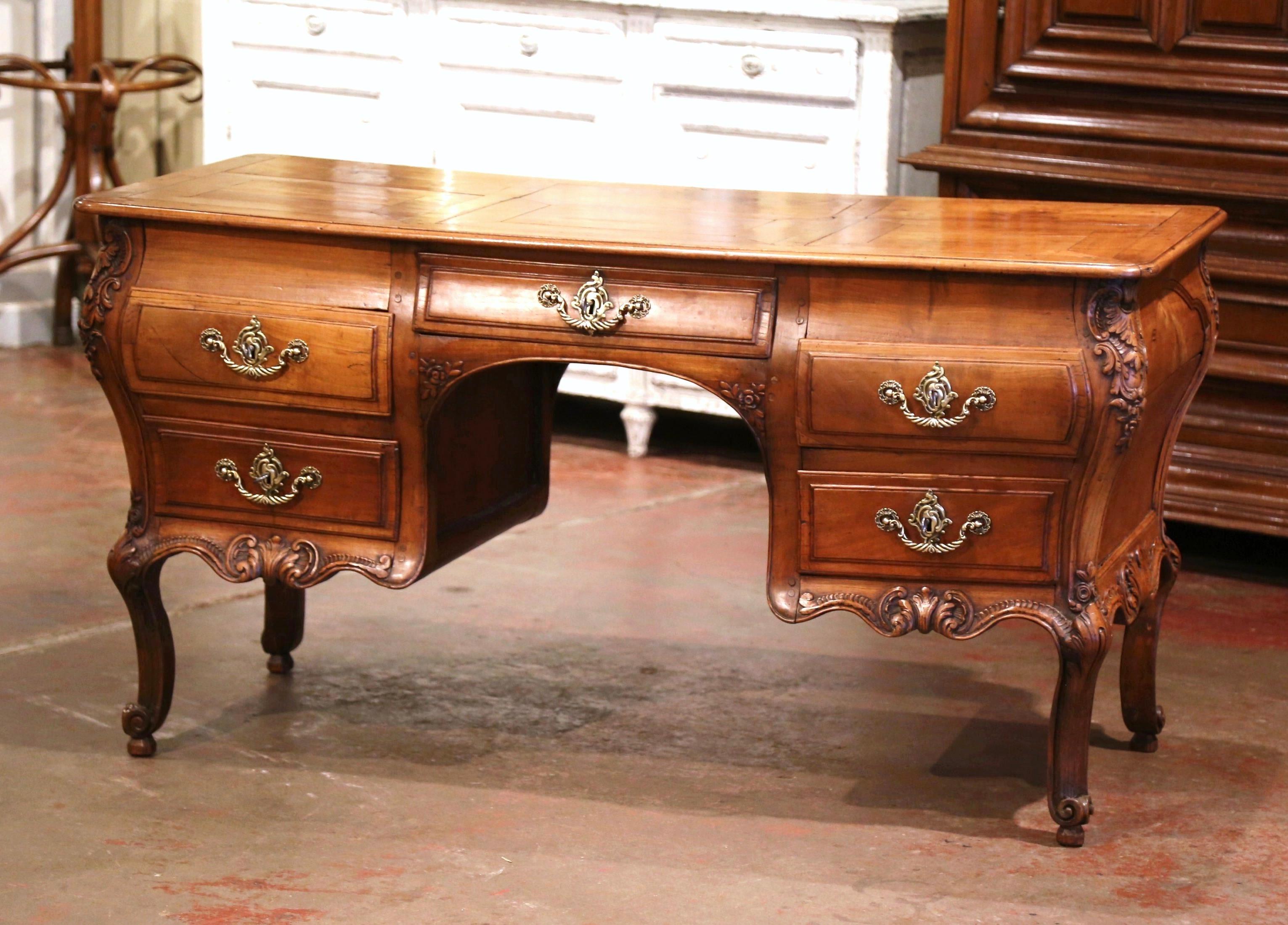 This elegant antique partner desk was created in the Poitou region of France, circa 1790. Made of wild cherry timber, the large writing table stands on nicely carved cabriole legs decorated with acanthus leaves at the shoulders, and ending with