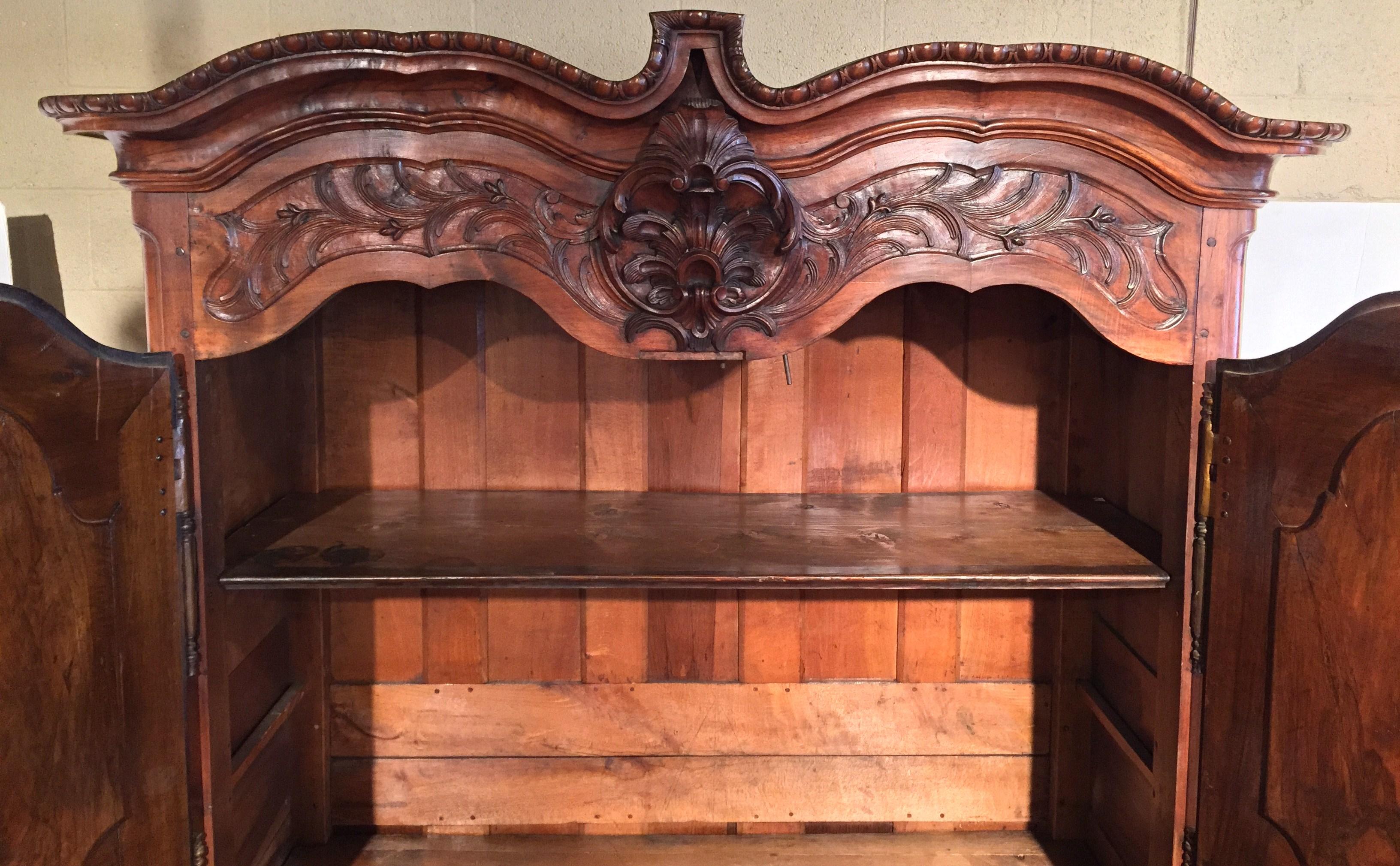 Patinato Armoire francese Luigi XV del XVIII secolo in noce intagliato proveniente da Lione in vendita