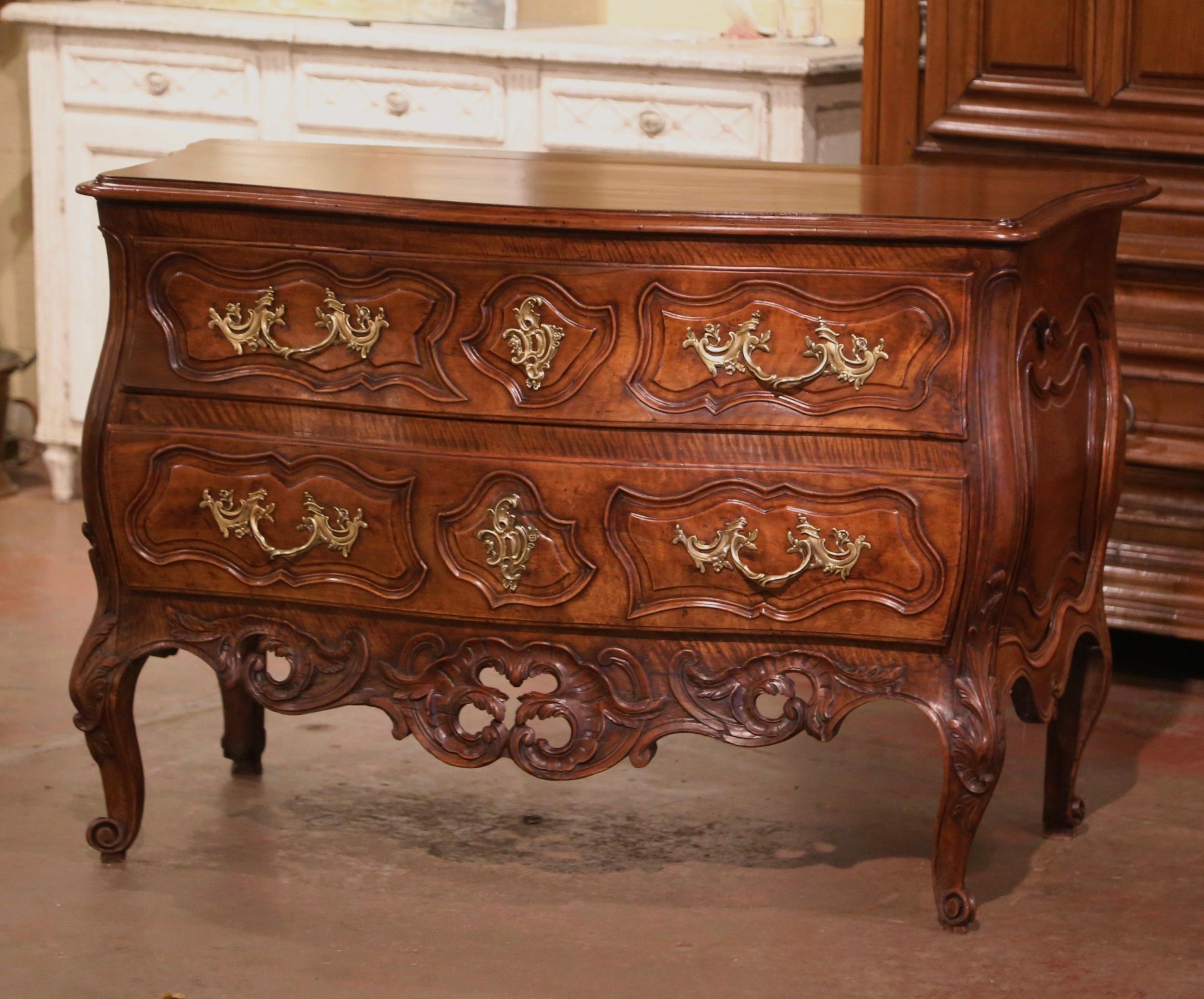 This important antique fruitwood commode was crafted in Nimes, Southern France circa 1750. The bombe chest on all sides, stands on cabriole legs decorated with acanthus leaves at the shoulder, and ending with escargot feet. The elegant scalloped and