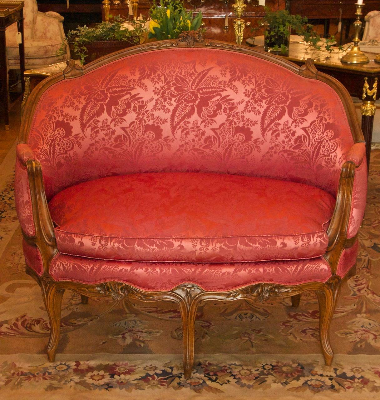 18th century French Louis XV carved walnut red silk settee 'Canape en Corbeille'

An 18th century Louis XV carved walnut settee 'canapé en corbeille' attributed to Pierre Nogaret (1718 - August 23, 1771). The padded back with a cresting centred by