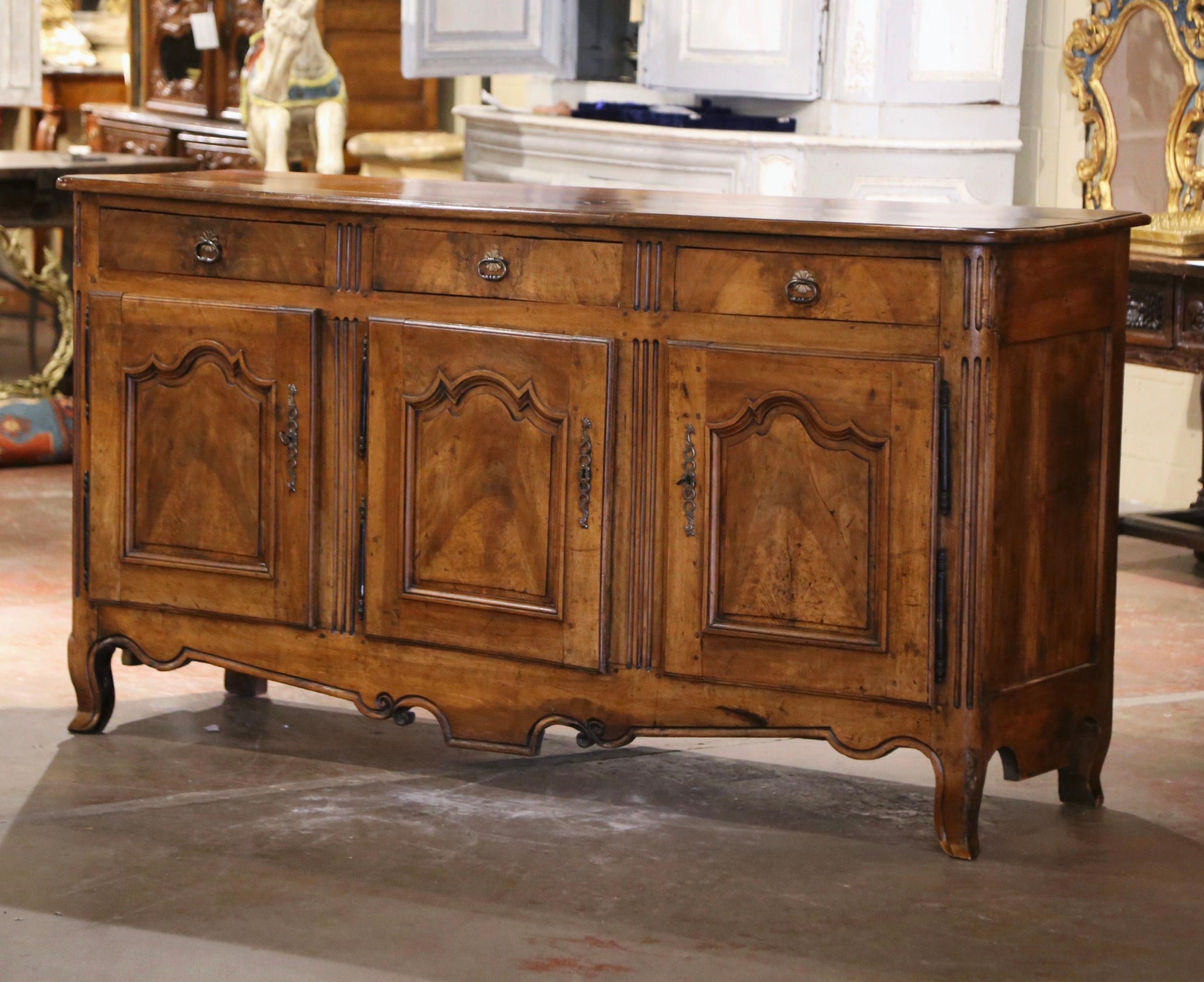 Decorate a dining room with this beautiful and functional antique enfilade. Crafted in the Burgundy region of France circa 1780, and built with solid walnut, the cabinet stands on curved feet over a scalloped apron. The buffet has three drawers