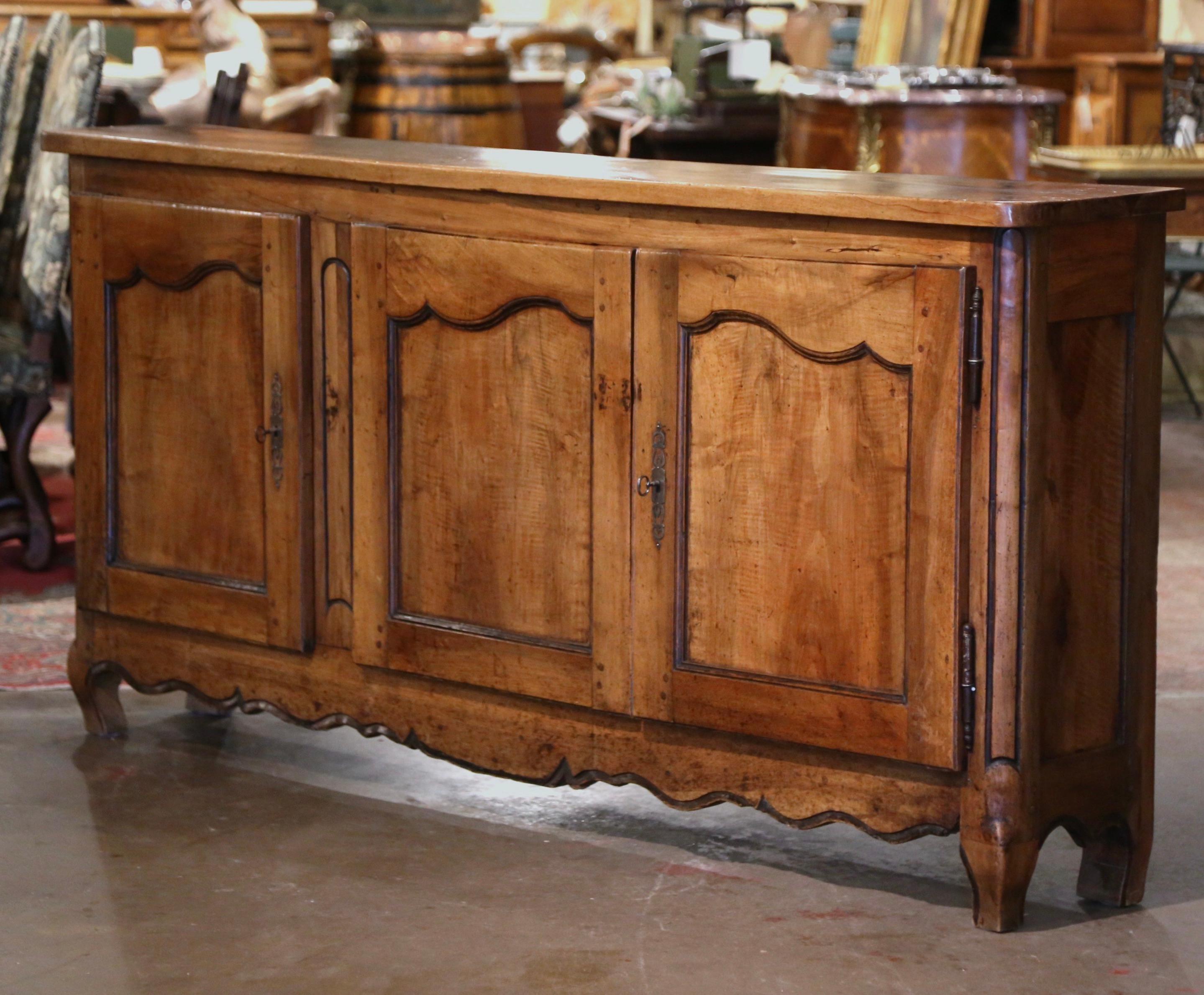 Beautiful and functional, this elegant antique enfilade from Southern France is not to be missed. Crafted in Lyon circa 1780, the buffet stands on curved feet over a scalloped apron. The cabinet has three doors across the front with recessed panels;