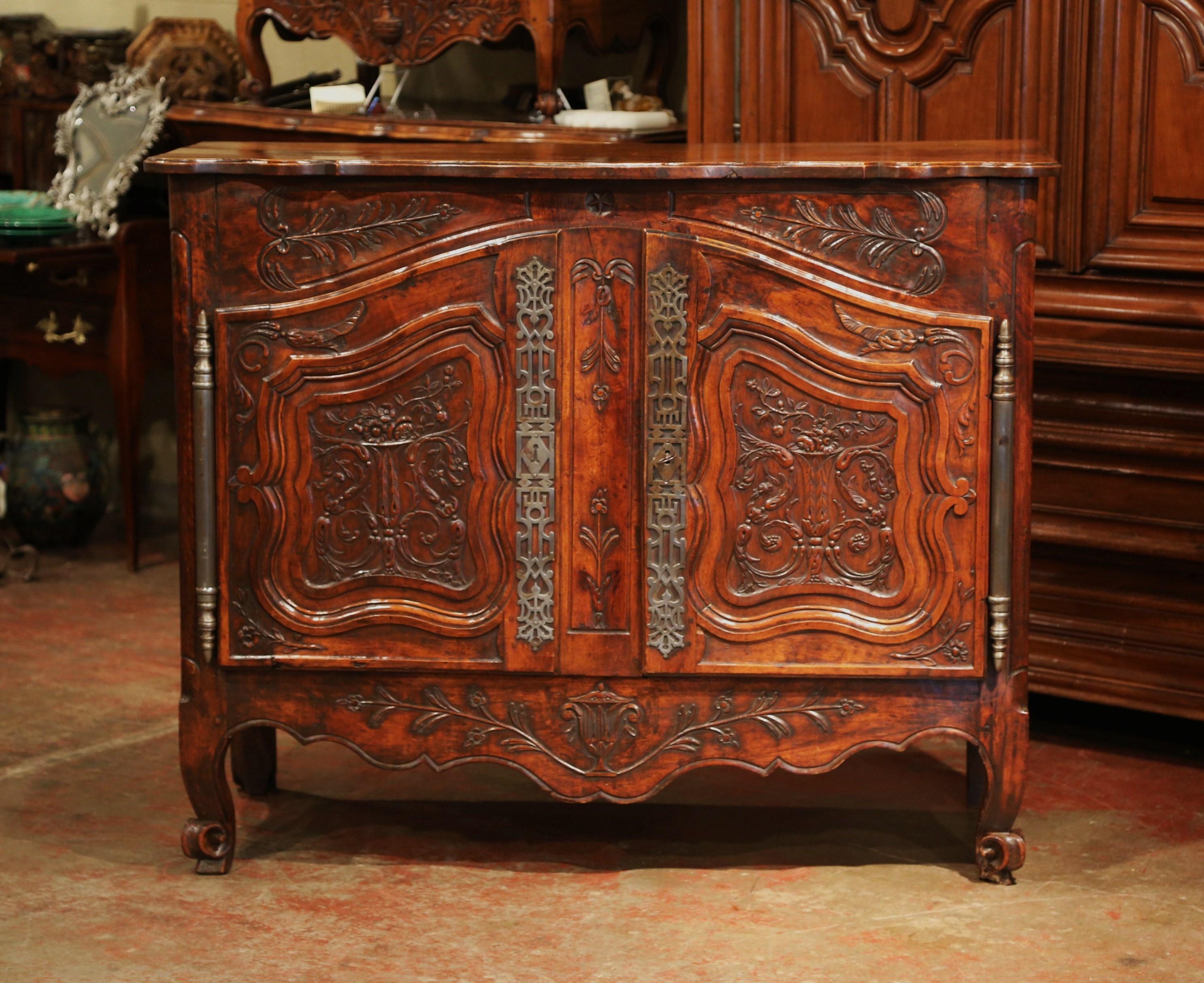 This elegant, antique fruit wood buffet was carved in Southern France, circa 1780. The Classic cabinet exemplifies the Louis XV style with a heavy presence, dramatic lines and intricate floral and foliage carvings throughout. The beautiful cabinet