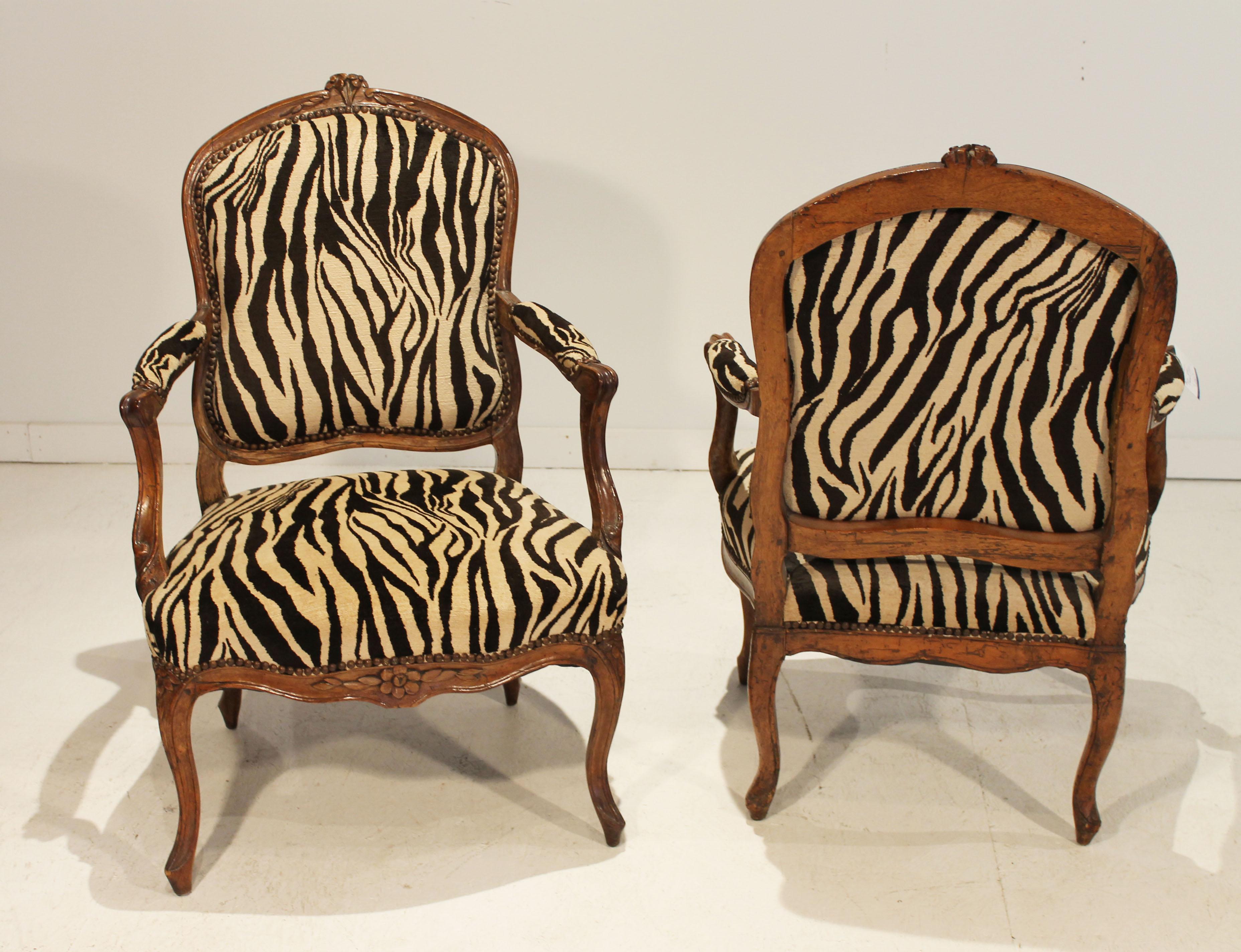 This pair of sophisticated French 18th Century Louis XV Arm Chairs with a gorgeous zebra print fabric and nail head accents would look beautiful in your living room or study. 
The elegant cabriole legs are adorned with the lovely delicate flower