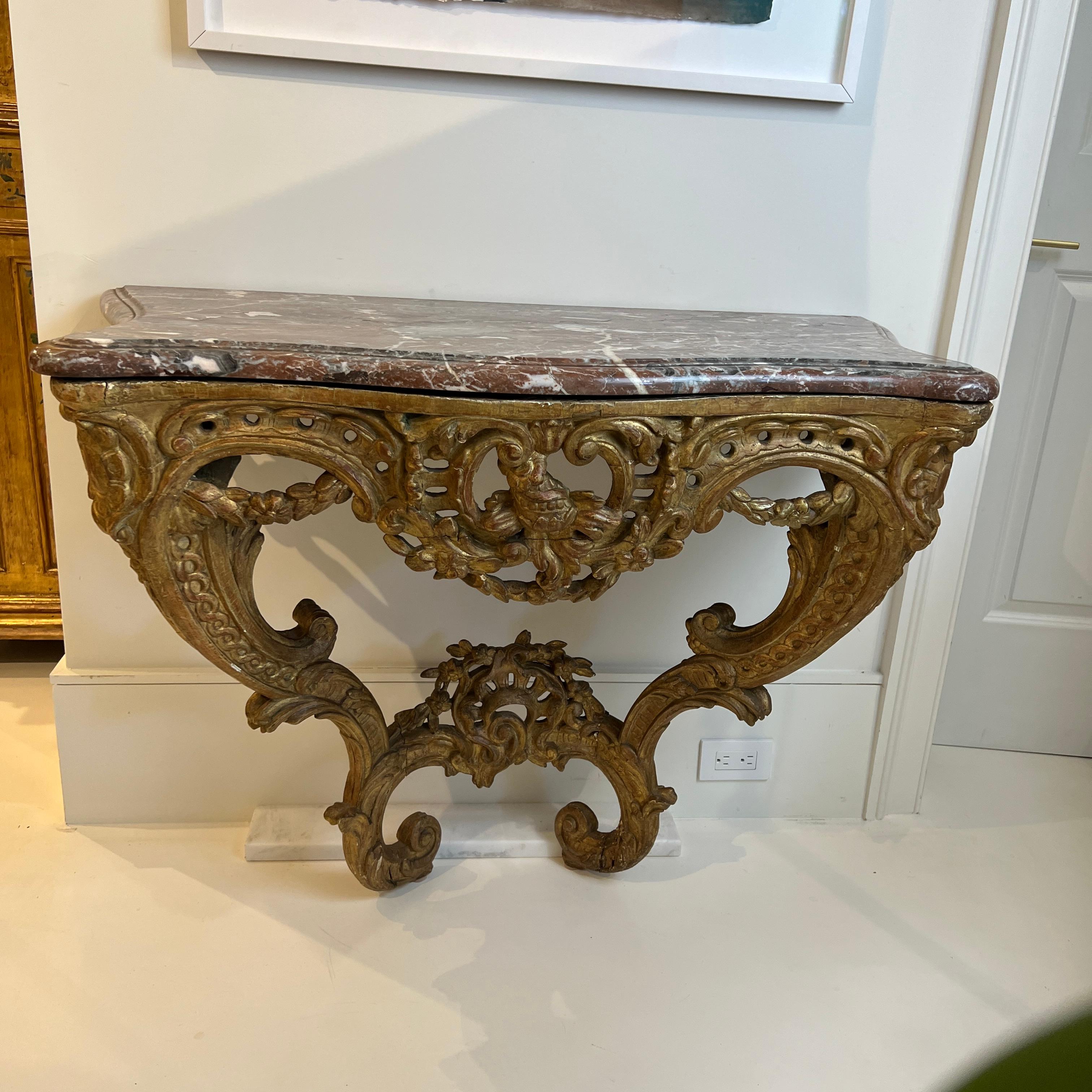 Small gilded console featuring marble top with OG edge.