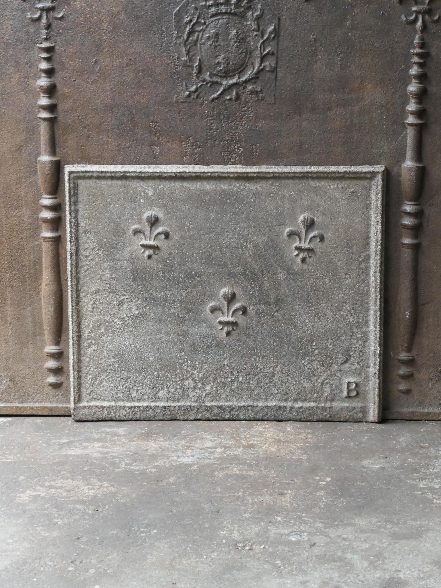 Beautiful 18th century French Louis XV fireback with three Fleurs de Lys. The Fleur de Lys (French Lily) symbolized royalty and aristocracy throughout Europe. The pillars stand for the club of Hercules and symbolize strength and the unknown. 

The