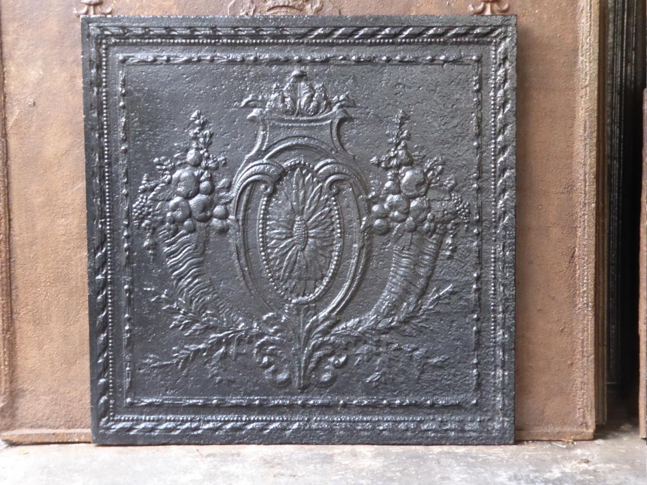 Beautiful 18th century French Louis XV fireback which is called 'Fruits of the Summer'. It has a sunflower, two horns of plenty filled with fruits, and other greenery. The fireback is made of cast iron and has a black patina. It is in a good