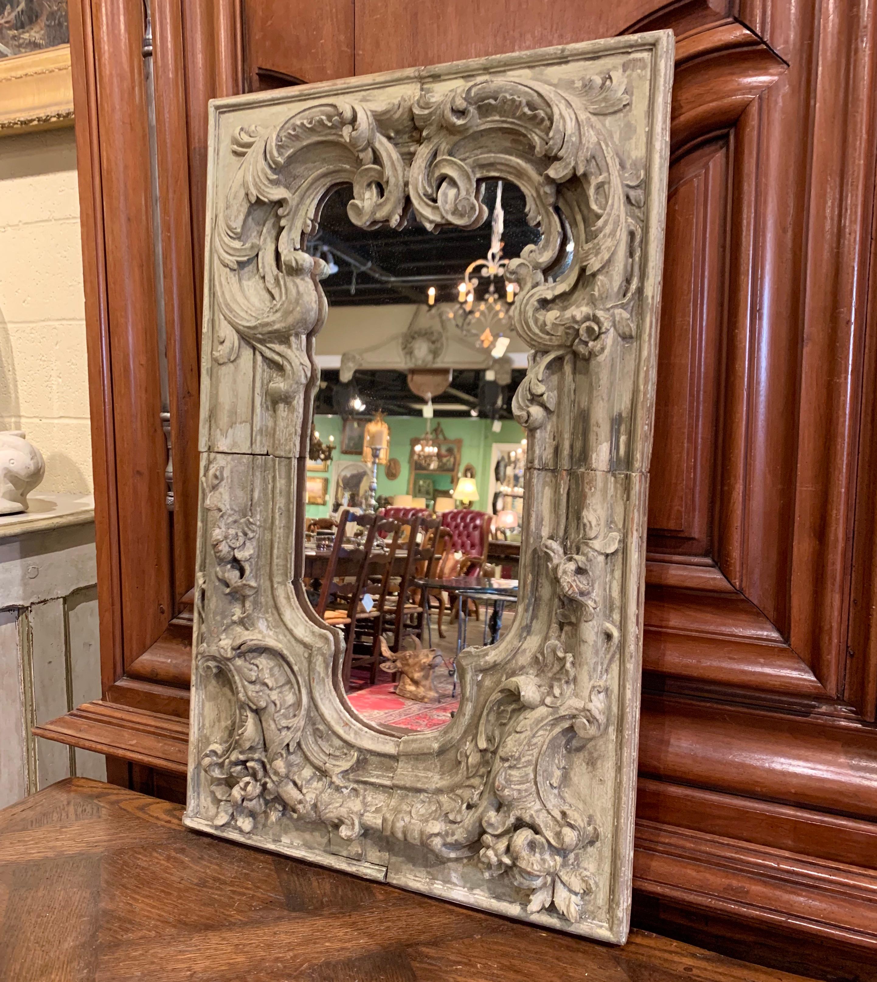 Hand carved in oak with old elements circa 1780, the rectangular frame features scrolled decor embellished with acanthus leaf and floral motifs in high relief. The mirror is in very good condition commensurate with age and use and adorns the