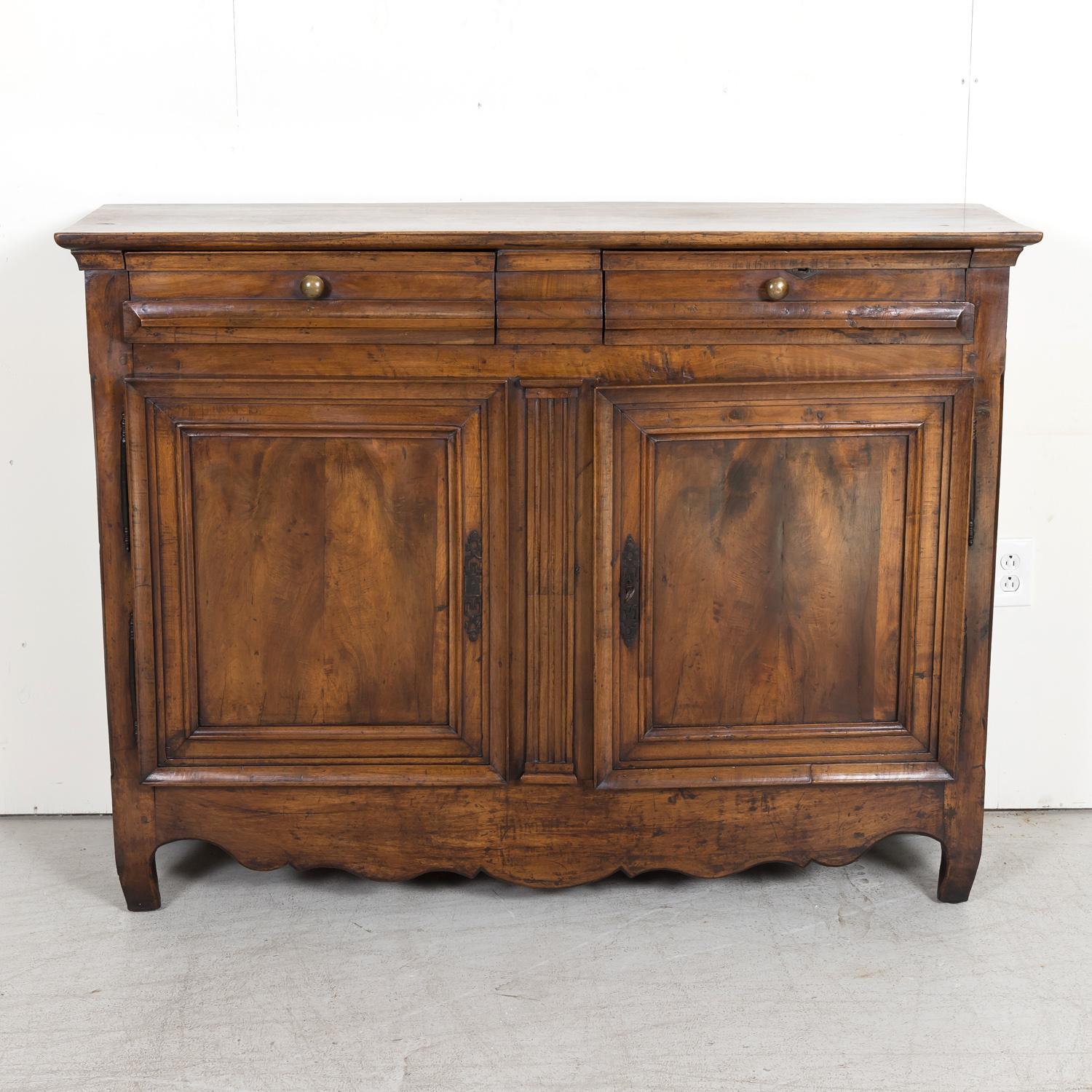A handsome 18th century French Louis XV-Louis XVI Transition period solid walnut buffet d'appui or gentleman's buffet handcrafted by skilled artisans from Lyon during the French Transition period (1750-1775), having a rectangular plank top that sits