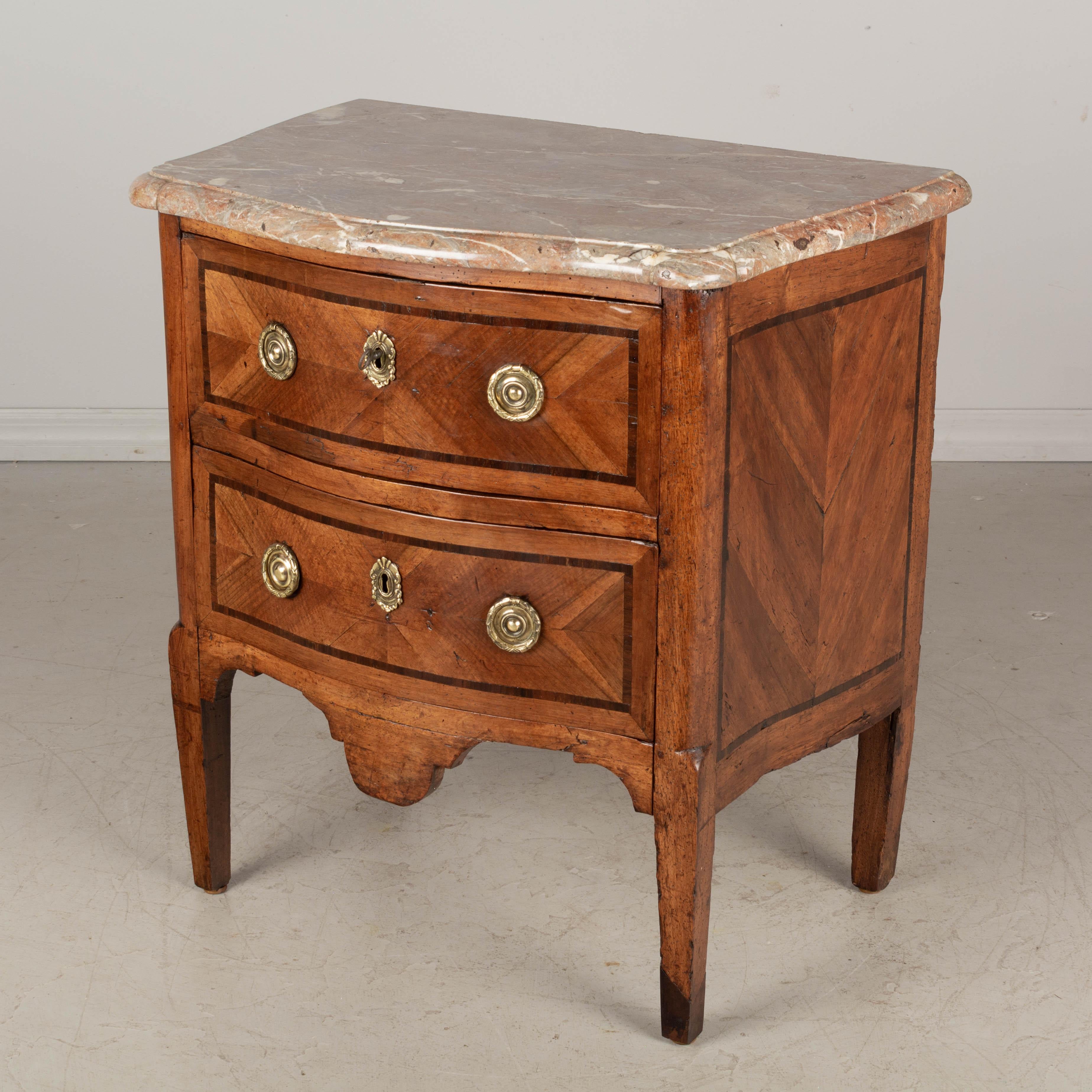 An 18th century French Louis XV style marble top serpentine front marquetry commode. Made of solid walnut with inlaid marquetry veneer of walnut. Original 1.25