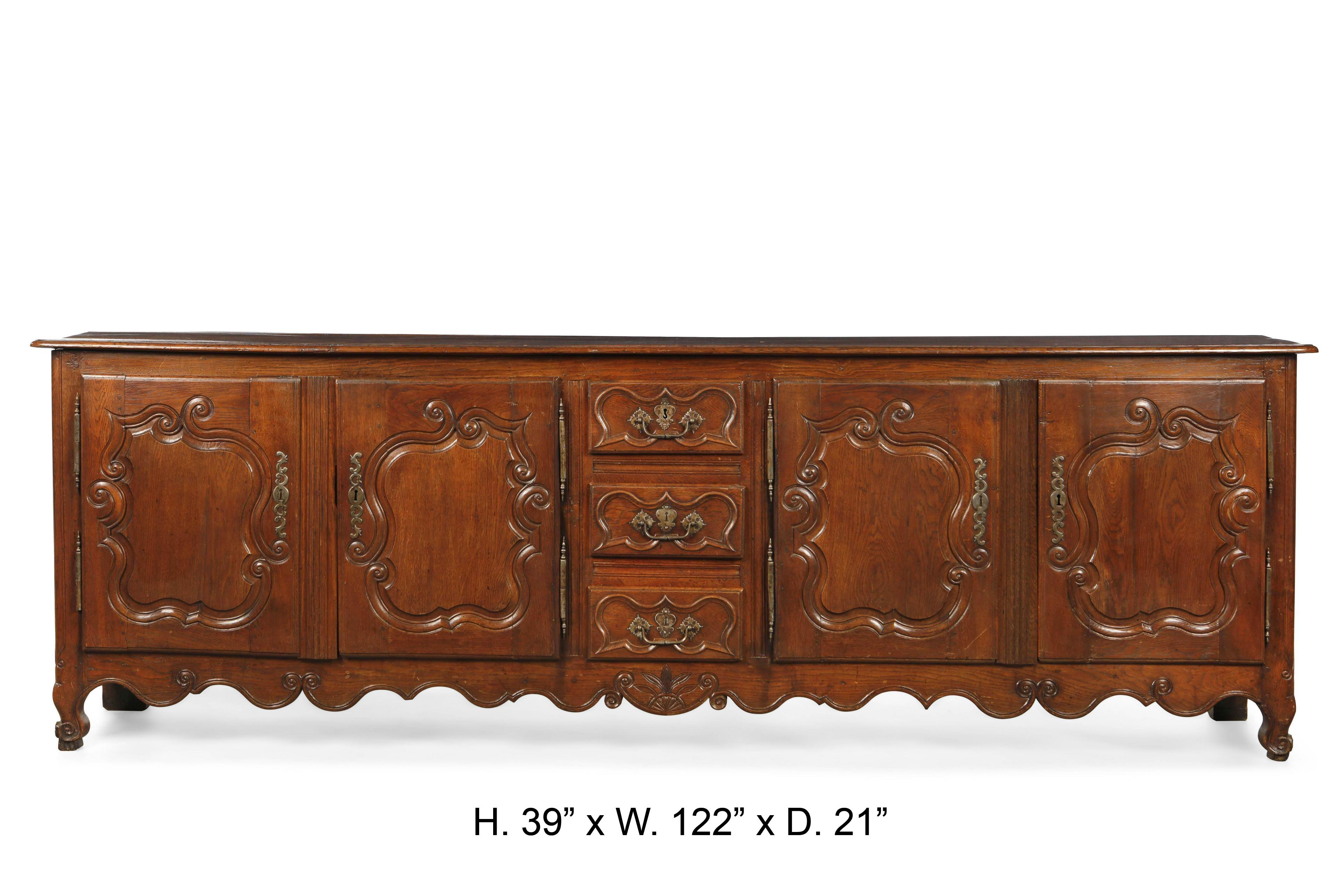 18th century French Louis XV carved oak buffet with four doors and centered by three carved drawers, all on bracket feet. With original locks.
This size buffet is very rare to find, especially in the 18th century.