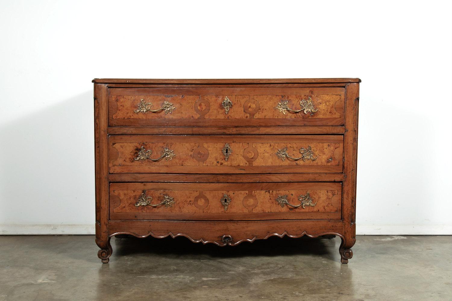 Exceptional mid-18th century French Louis XV period commode de galbée handcrafted of chestnut with burled chestnut and fruitwood parquetry by master artisans near Marseilles. Curved front having three drawers with gilt bronze lockwork, escutcheons