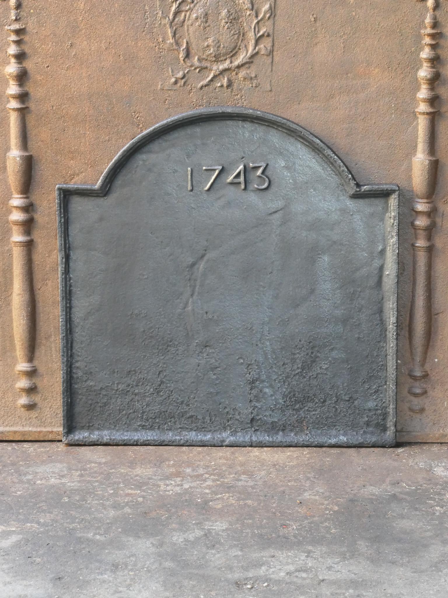 18th century French Louis XV period fireback. The date of production, 1743, is cast in the fireback. 

Made of cast iron. The fireback has a black / pewter patina.