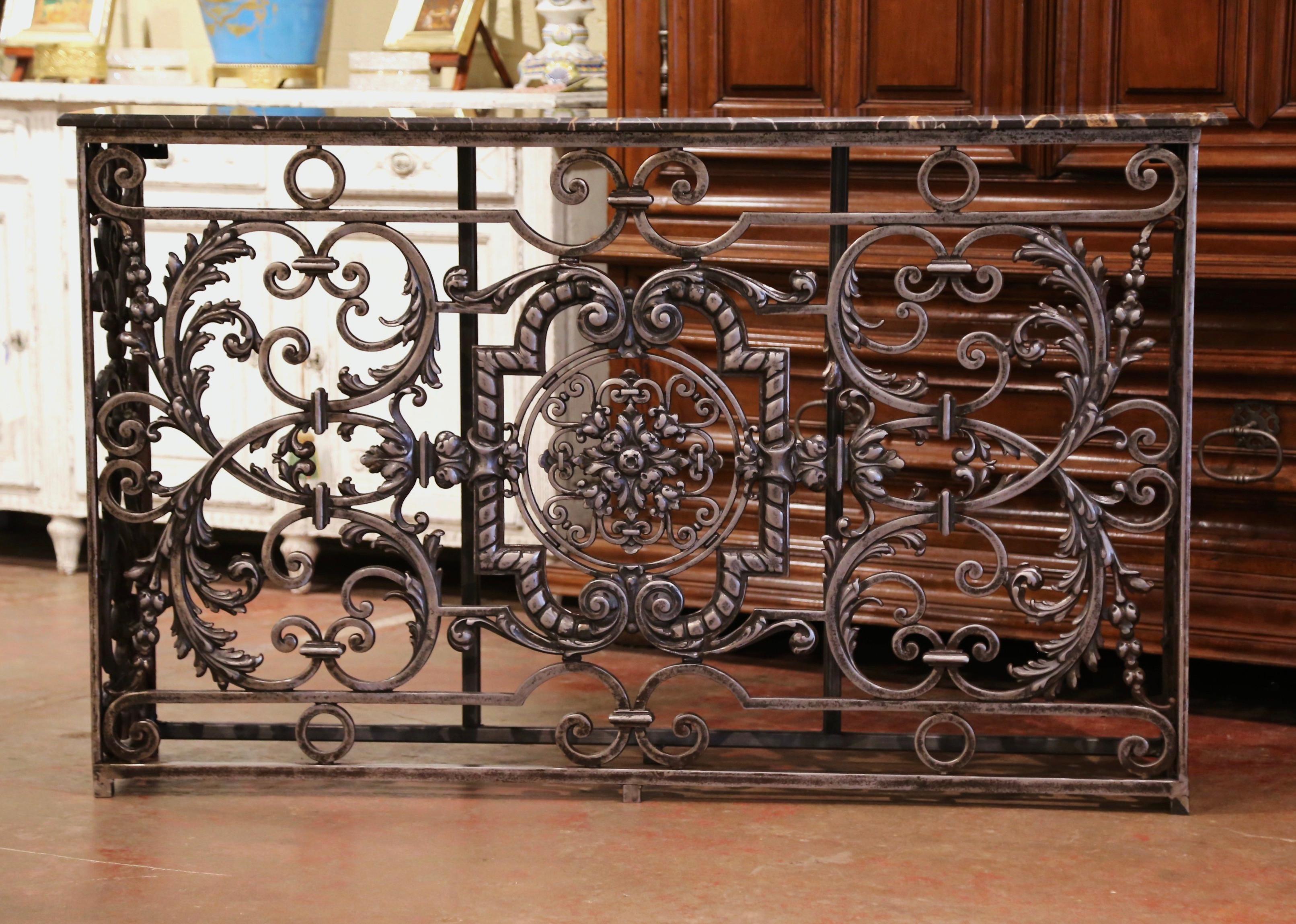 Crafted in Paris France circa 1780, the antique console table base stands on straight feet connected with a bottom stretcher. The Louis XV style table features intricate scrolled and leaf decor on all three sides, embellished with a central round