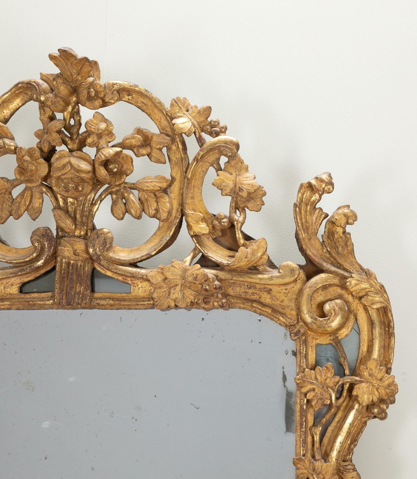 Importante gran espejo provenzal Luis XV francés del siglo XVIII. De bella construcción tallada a mano, con su placa original de espejo de mercurio. Envuelta en un marco de madera dorada maravillosamente elaborado con tallas de uvas, vides y hojas
