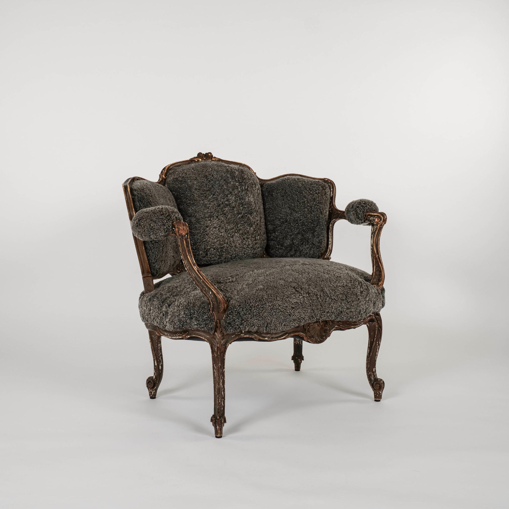18th-century French Louis XV polychrome and giltwood bergère newly upholstered in a charcoal sheepskin.