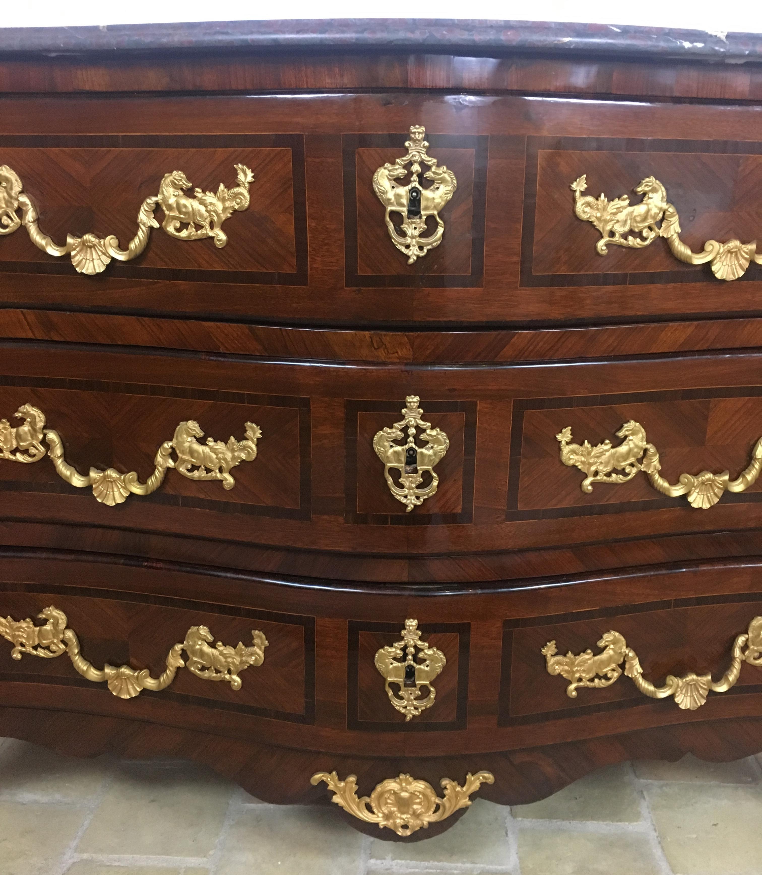 Fantástica cómoda francesa de principios del siglo XVIII con forma de galera o bombe serpentina, embellecida con hermosas monturas y accesorios originales de bronce ormolu. Ambas caras tienen forma de bombe con un detallado trabajo de