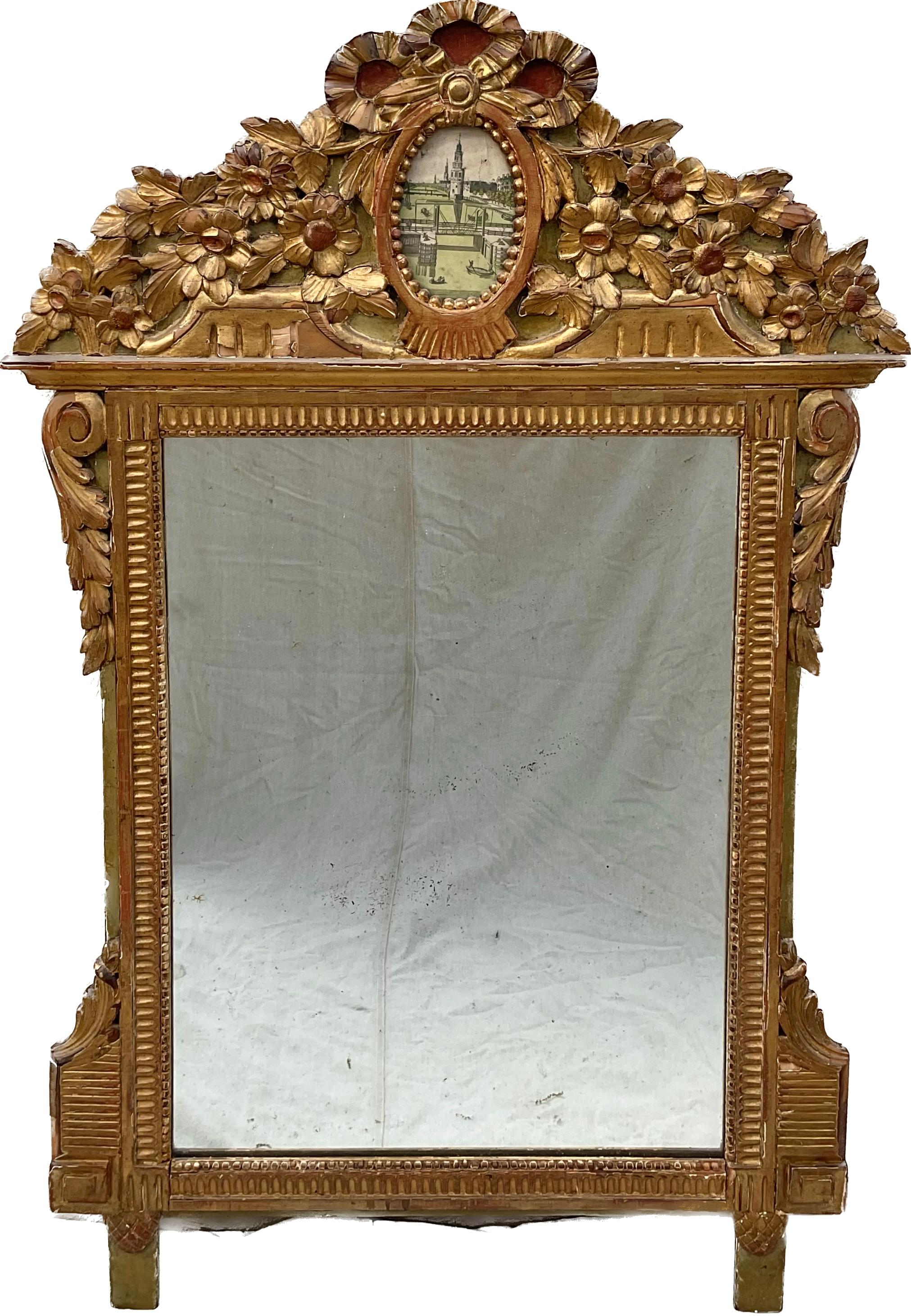 This elegant, 18th century Louis XVI Mirror would make a charming addition to any interior decor. Crafted in Southern France, circa 1780, the mirror is heavily carved and exemplifies the design elements of the Rococo and Baroque style. The pediment