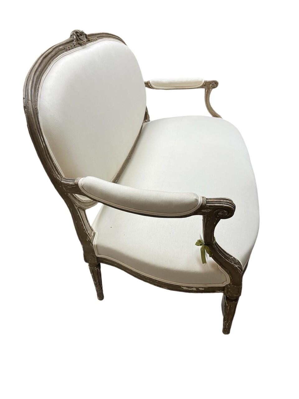 Canapé Louis XVI français du 18ème siècle, sculpté, avec une tapisserie d'origine en crin de cheval. Le cadre est en très bon état vintage avec quelques pertes de peinture mais très robuste. Motifs d'acanthe et pieds cannelés et effilés.