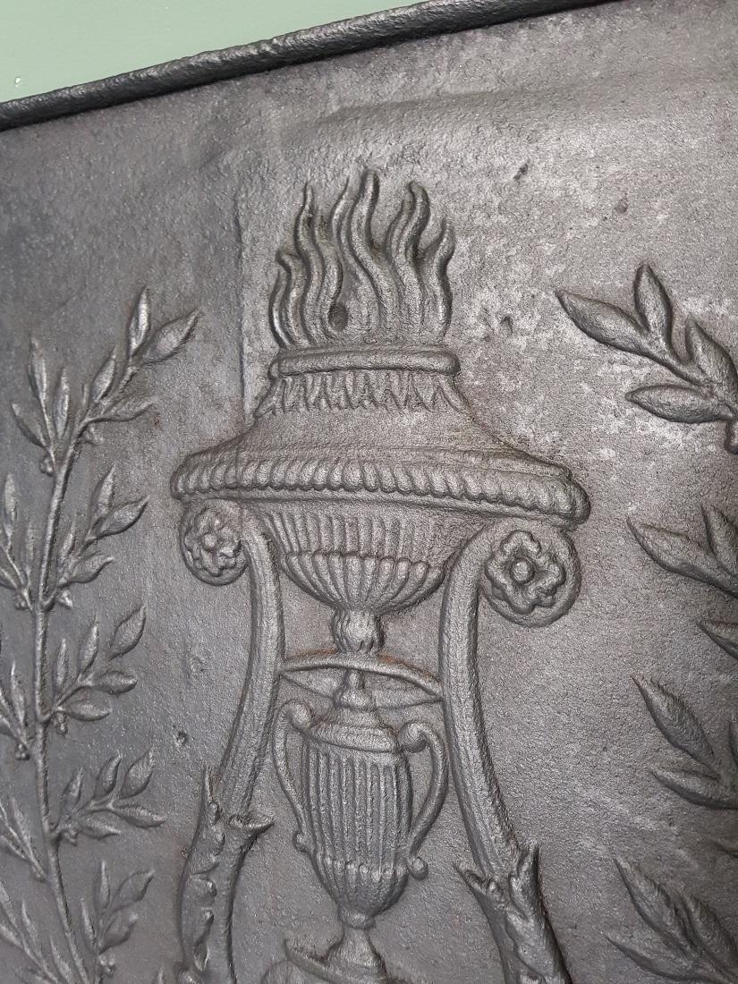 Antique French cast-iron Louis XVI hob with typical relief image from that time of a vase with flames and standing on claw feet, late 18th century.

The measurements are,
Depth 2 cm/ 0.7 inch.
Width 50 cm/ 19.6 inch.
Height 50.5 cm/ 19.8 inch.